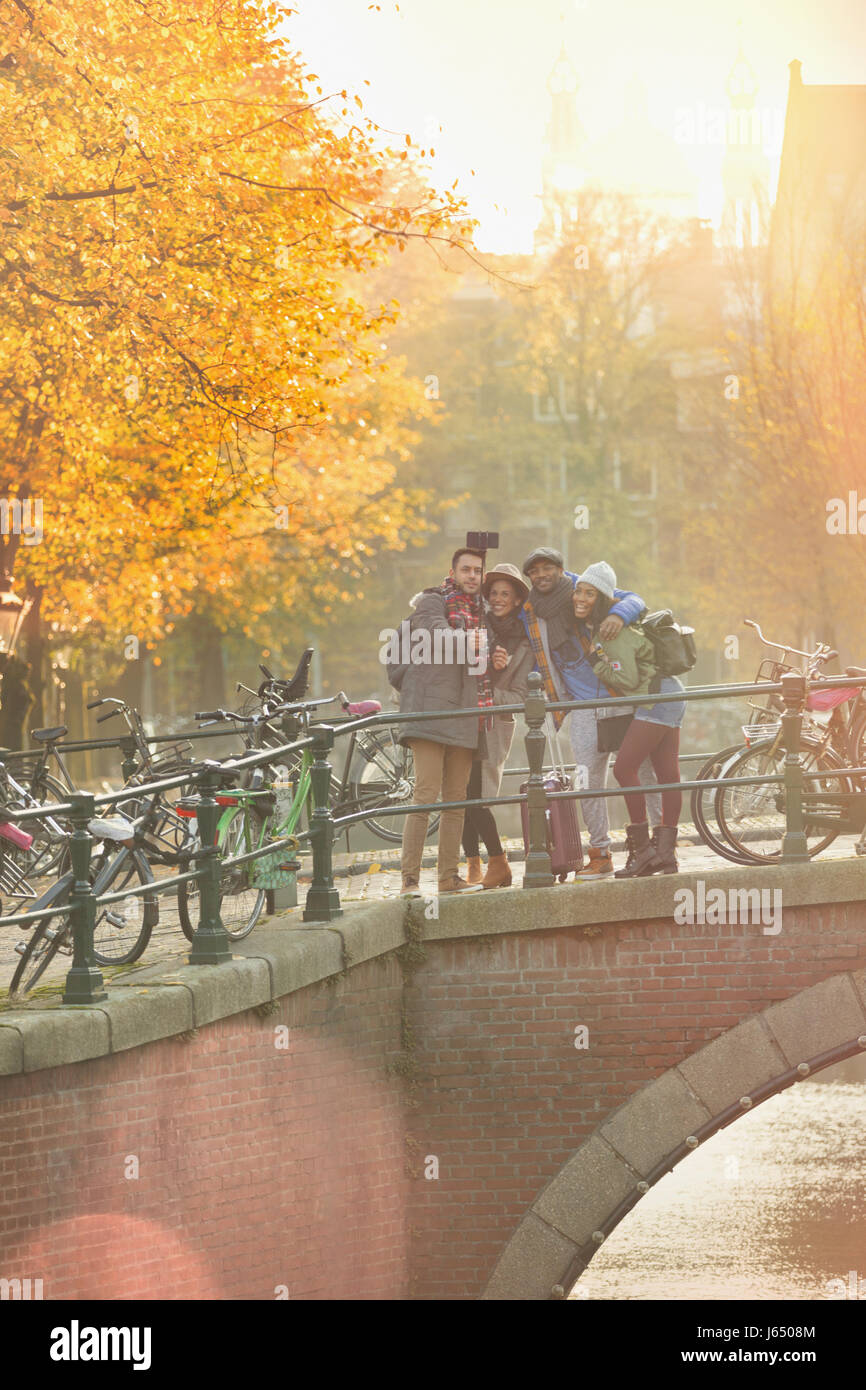 Freunde nehmen Selfie mit Selfie aufkleben Herbst Brücke über den Kanal in Amsterdam Stockfoto