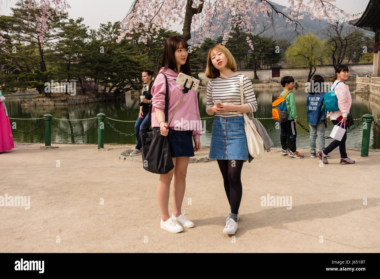 Zwei junge Frauen nehmen Selfies mit einem Mobiltelefon & Selfie kleben im Gyeongbokgung Palace. Seoul, Südkorea Stockfoto