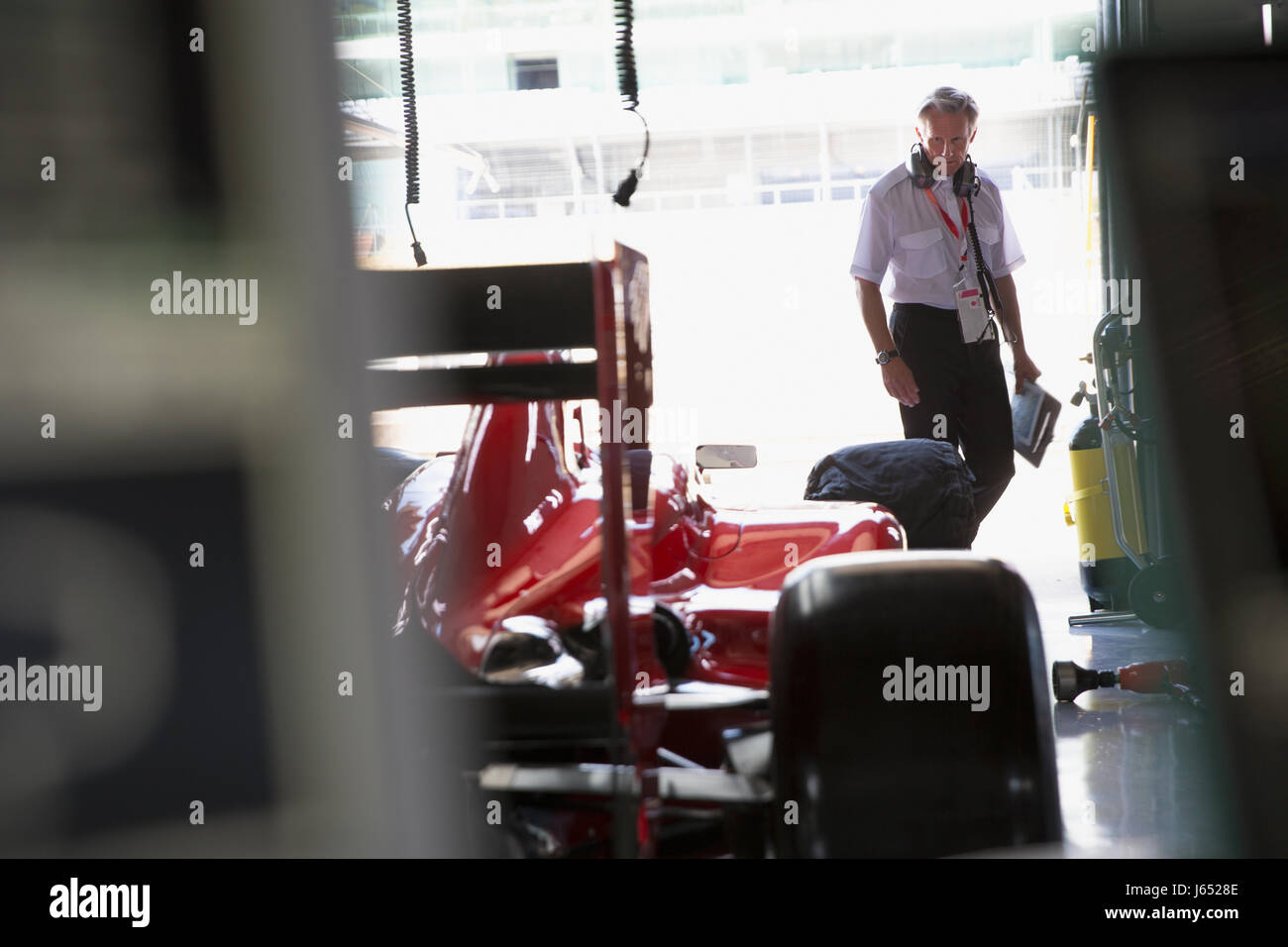Manager Prüfung Formel 1 Auto in Werkstatt Stockfoto