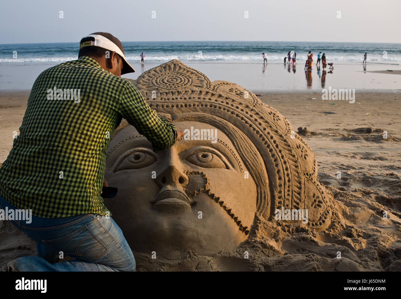 Sand-Künstler bei der Arbeit, Strand, Golf von Bengalen (Indien). Die Skulptur stellt die hindu-Göttin Lakshmi. Stockfoto