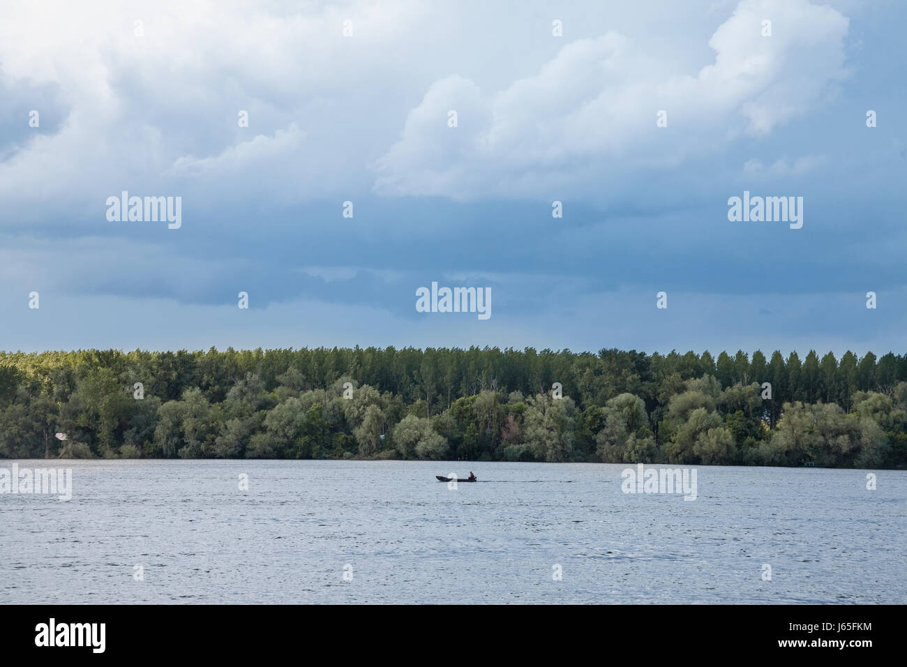 Bild eines Bootes auf einem kanadischen Stil-See, während ein bewölkt am Nachmittag Bild von einem kanadischen Stil-See mit einem Boot auf es während einem bewölkten vorbei ein Stockfoto