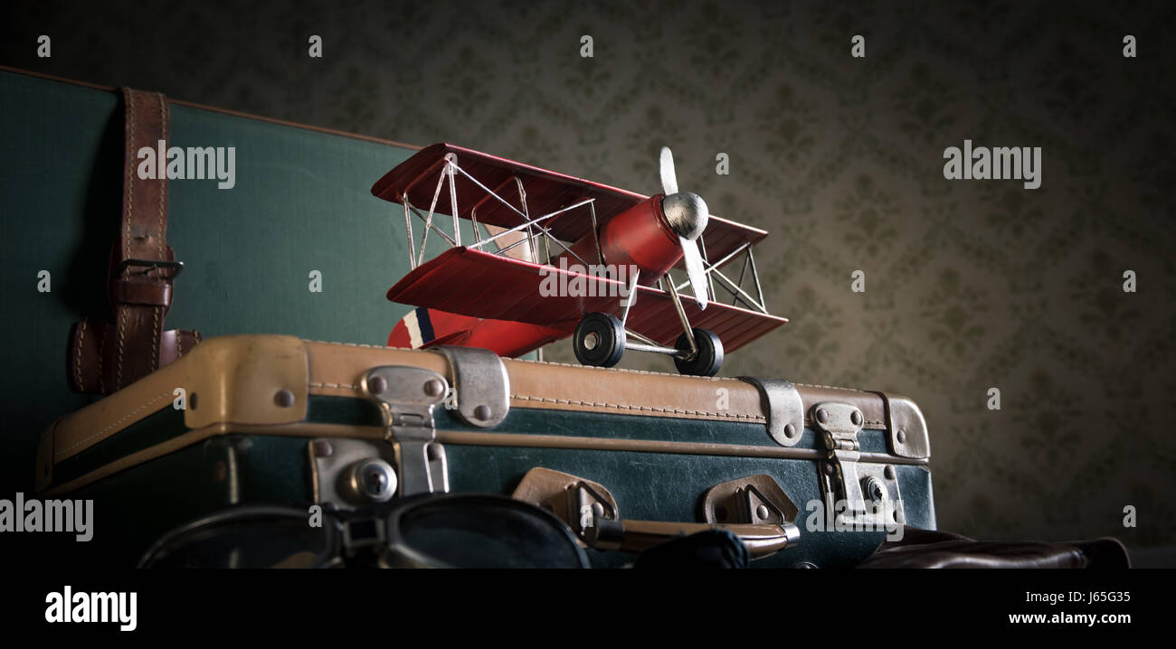 Koffer auf dem Boden mit Karten und Spielzeug aus Holz Flugzeug. Stockfoto
