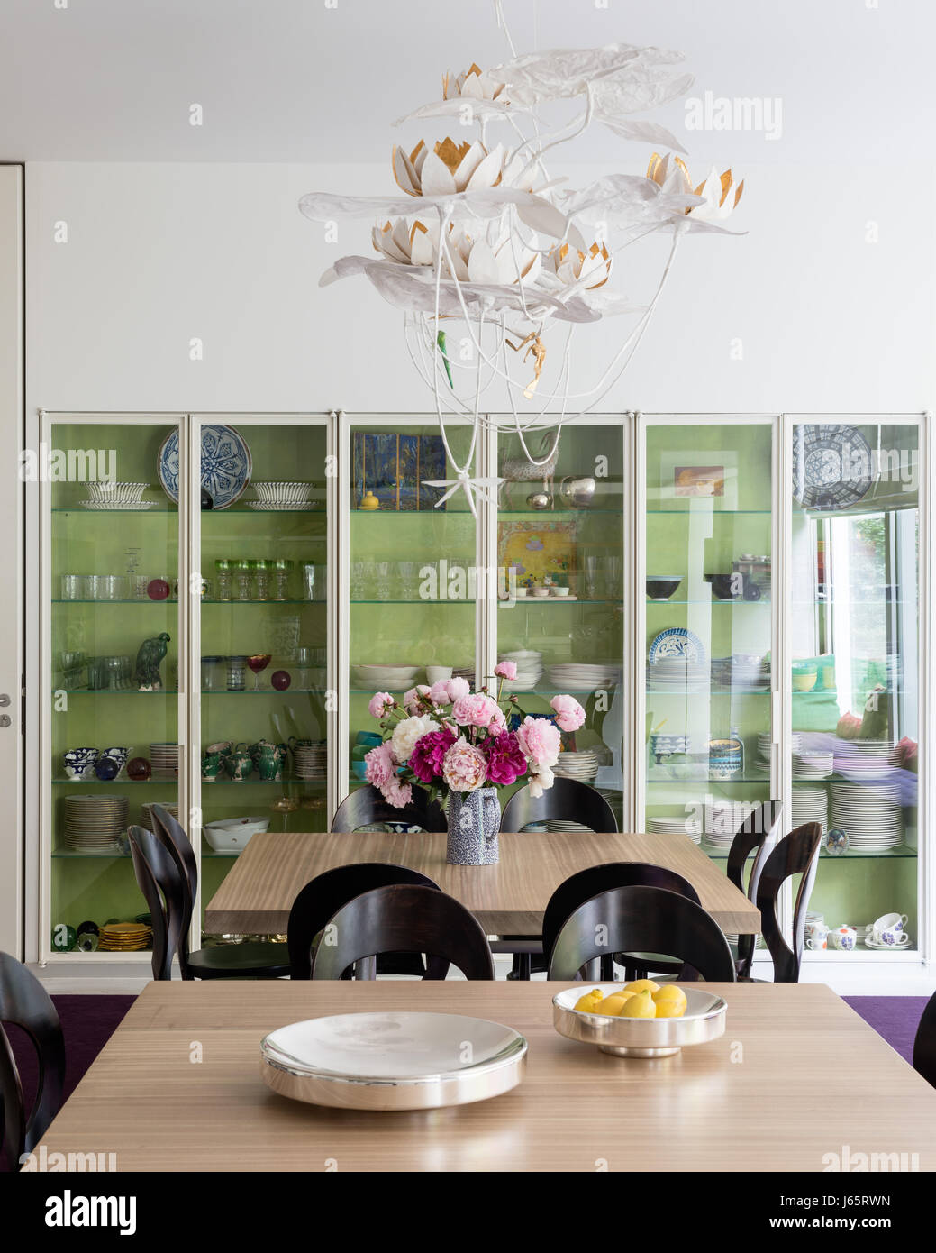 Glasfront Schrank mit Tabellenpaar Eiche gekrönt und alten Stühlen ermöglichen 16 auf einen Tisch zum Abendessen Stockfoto