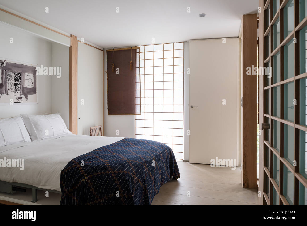 Zen-artige Schlafzimmer mit weißem Laminat, Eiche und Rattan-Bildschirme Stockfoto