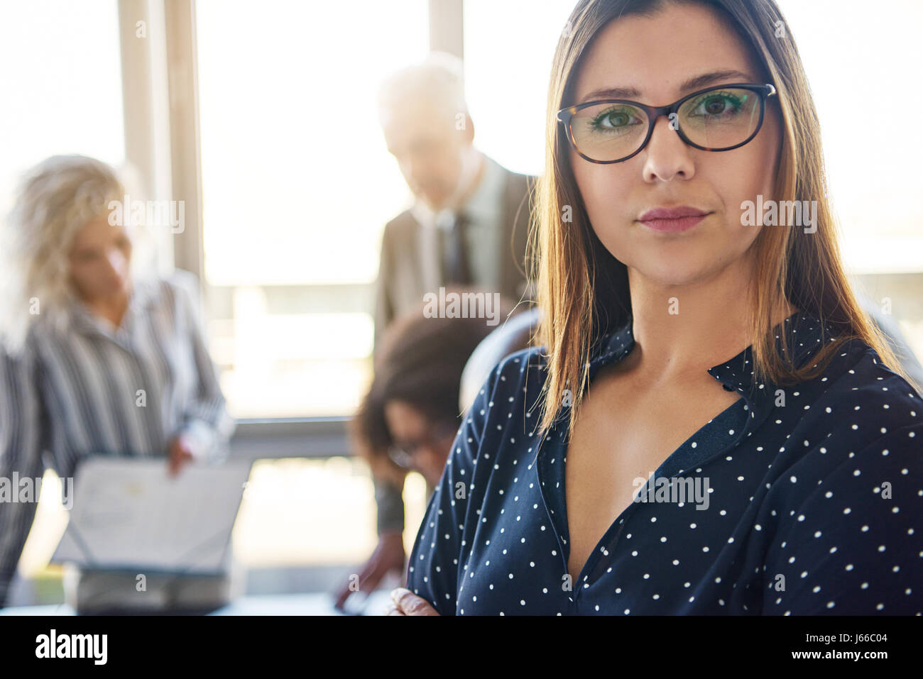 Ernste Angelegenheit Frau vor Team im Büro, Blick in die Kamera Stockfoto