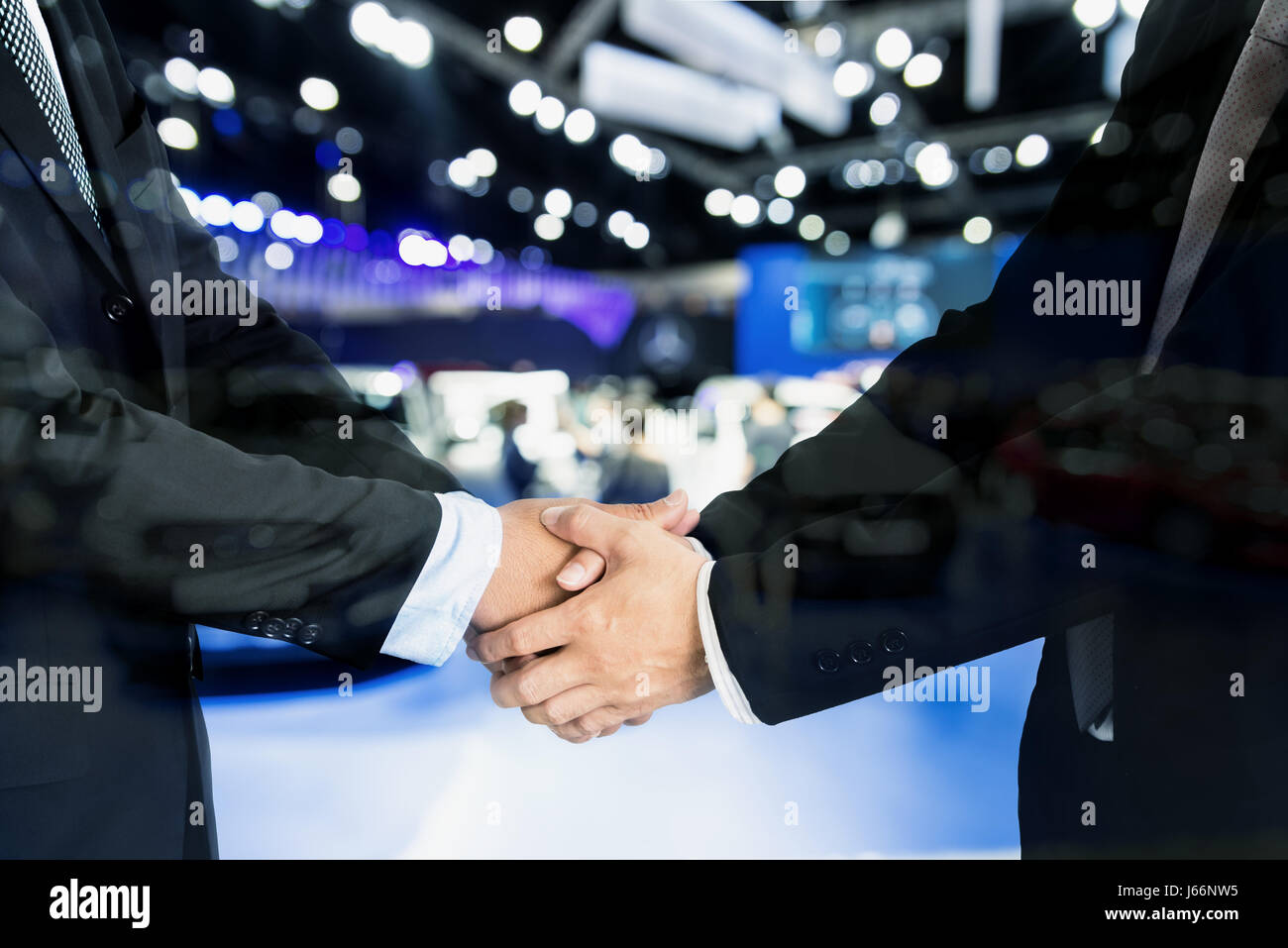 Auto-Geschäft, Autoverkauf, Deal, Geste und Menschen Konzept - Nähe bis der männlichen Handshake Automesse oder Salon. Stockfoto