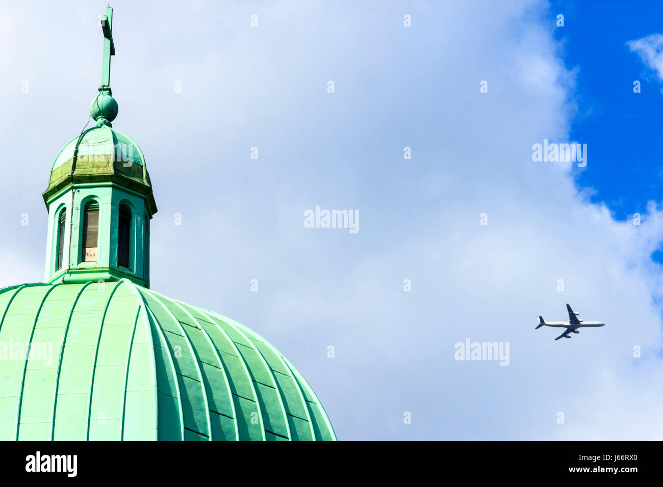 Ein Flugzeug übergibt die grüne Grünspan - überdachte Kupfer Kuppel der St. Josephs Kirche auf Highgate Hill, London, UK Stockfoto