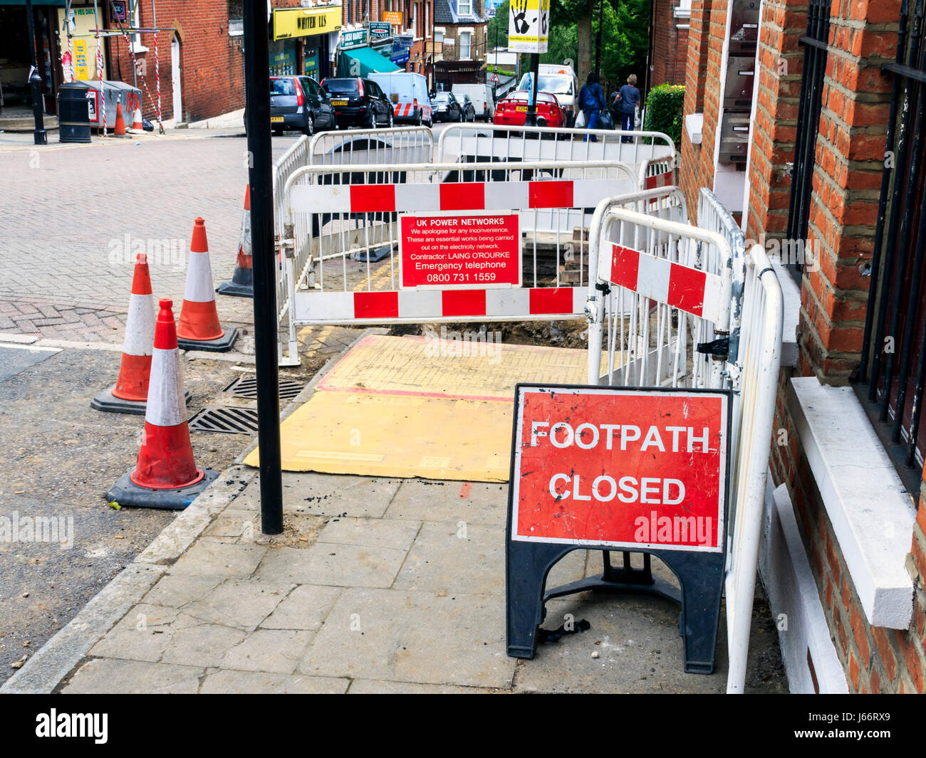 Rote und weiße Warnleuchte Marker, Kegel und Fechten, Fußweg für Reparaturen in Islington, London, UK geschlossen Stockfoto