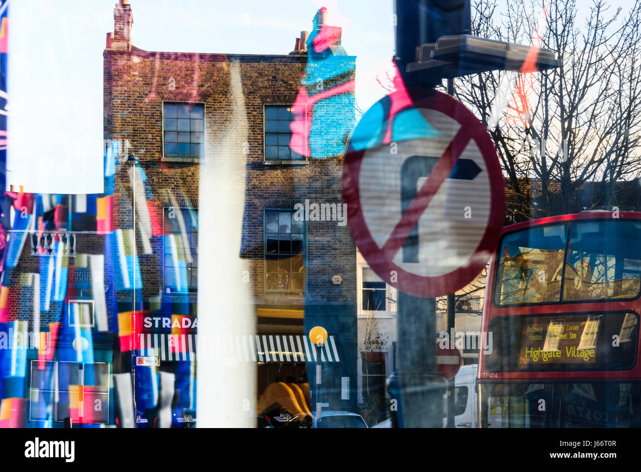 Abstrakte Komposition durch die Reflexionen des Rechts, Bus, Gebäuden und helle Farben in einem Schaufenster in Highgate, London, UK Stockfoto