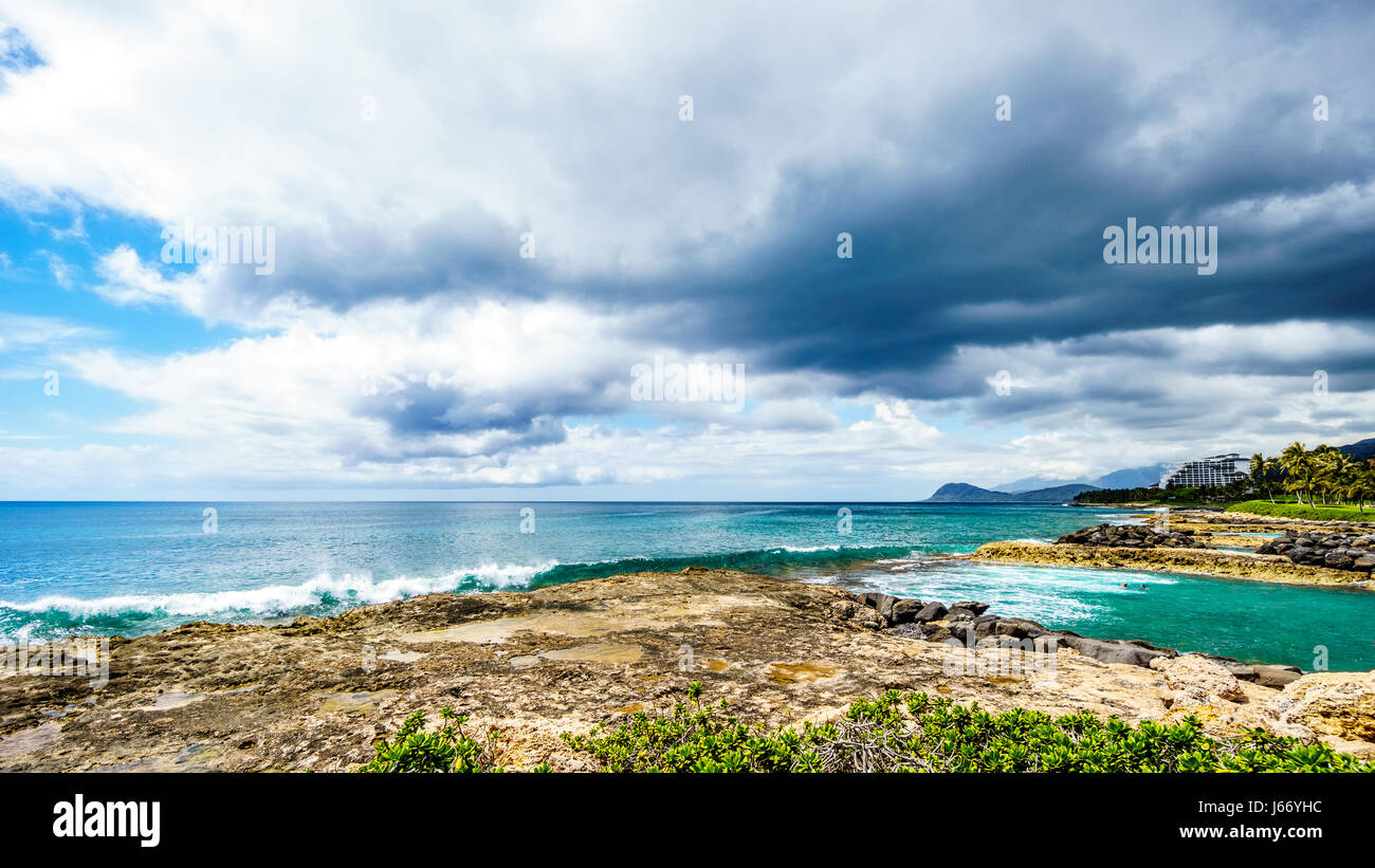 Palmen im Wind an den Ko Olina Lagunen unter bewölktem Himmel an den Lagunen der Ko Olina an der Westküste von der hawaiianischen Insel Oahu Stockfoto