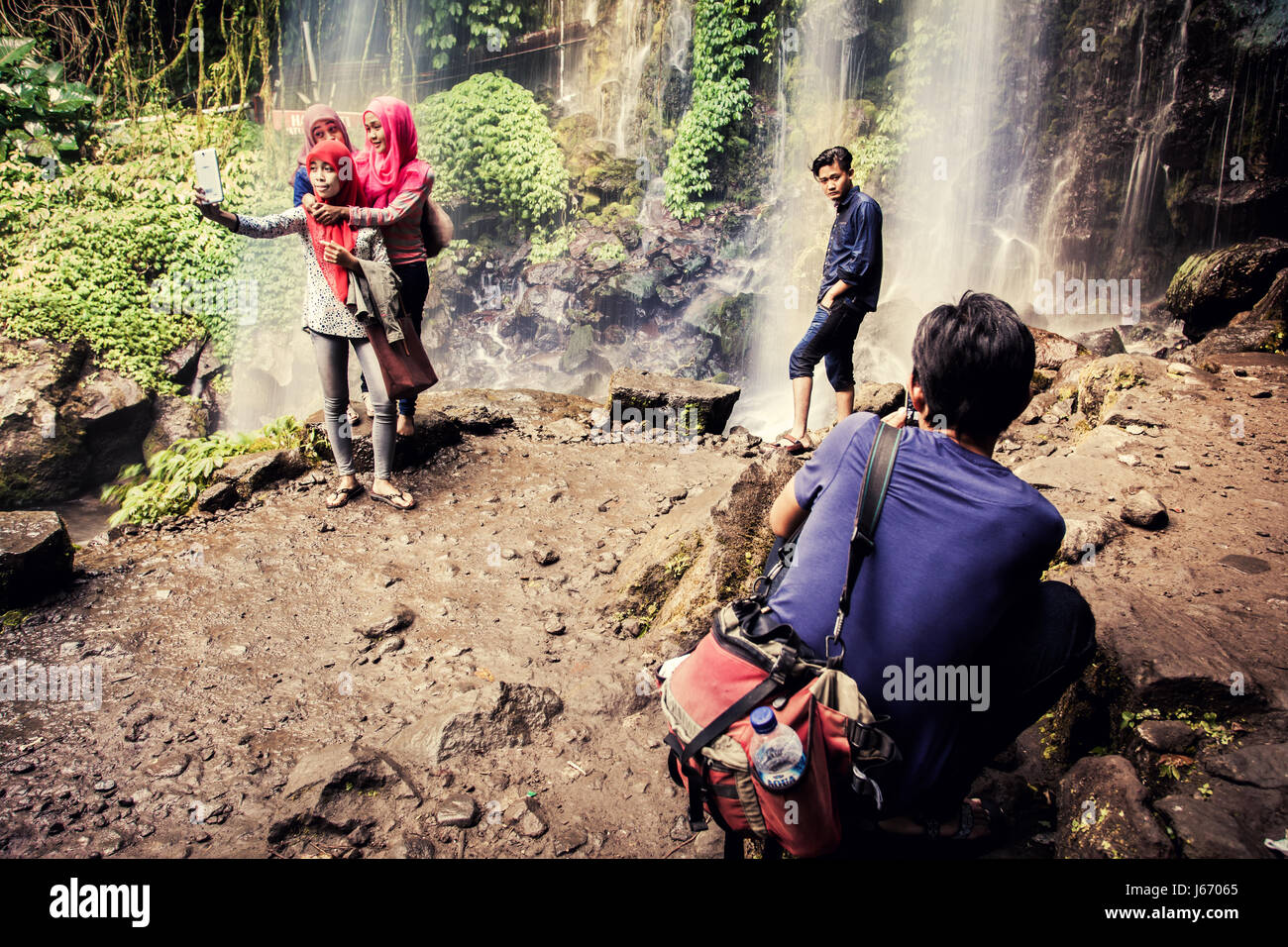 Kreative Bild, Indonesier, die Einnahme von Selfies am Jumog Wasserfall in Java, Indonesien. Atemberaubende Kulisse eines Wasserfalls aufgenommen mit Langzeitbelichtung Technik Stockfoto