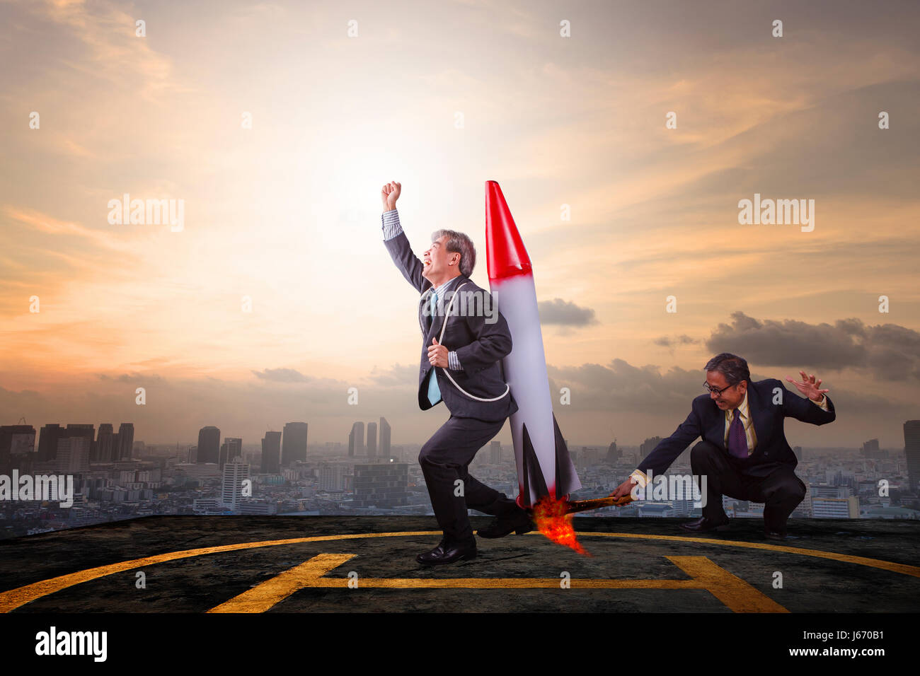 zwei Business-Mann spielen Spielzeug Rakete auf hohe Gebäudedach mit Sky Scraper Hintergrund abstrakt für erfolgreiche Business-partner Stockfoto