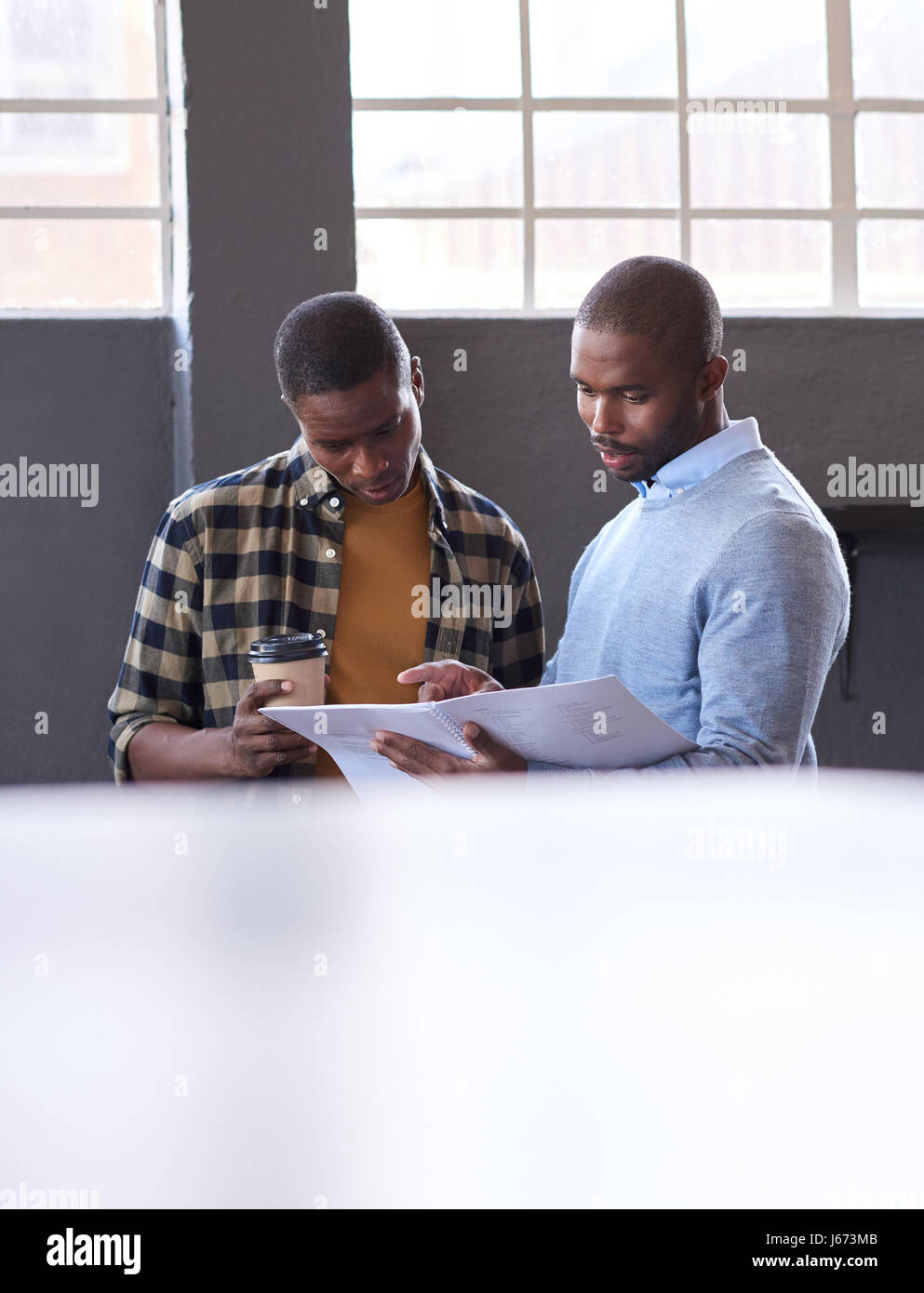 Afrikanische Unternehmer sprechen über Papierkram zusammen in einem Büro Stockfoto