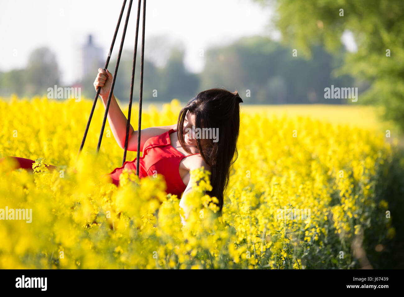Glücklich Sommerszene mit Frau auf einer Schaukel Stockfoto