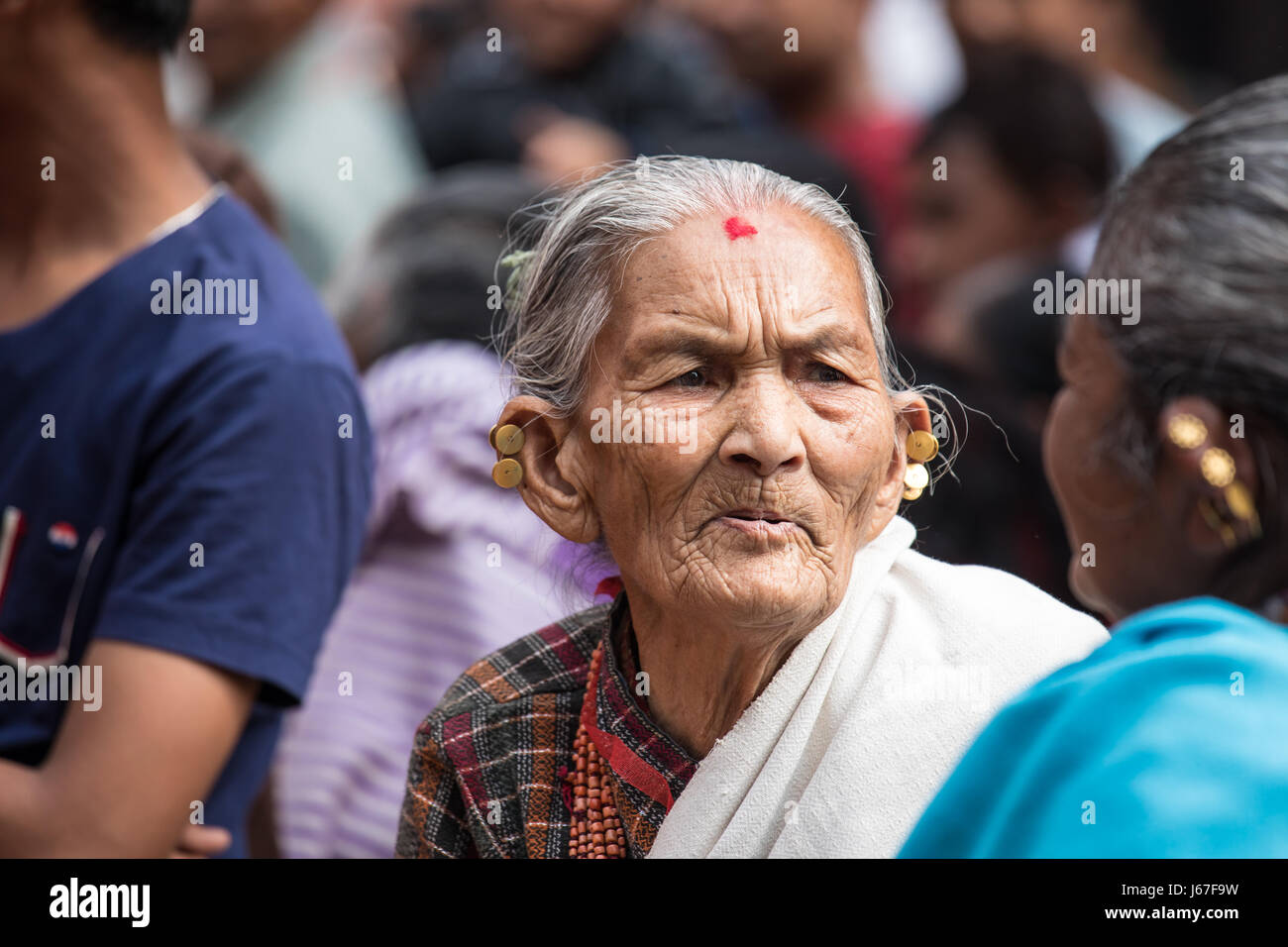 Kathmandu, Nepal - 15. April 2016: Ältere Damen in der traditionellen nepalesischen Kleidung beobachten eine vorübergehende Zeremonie Prozession. Stockfoto