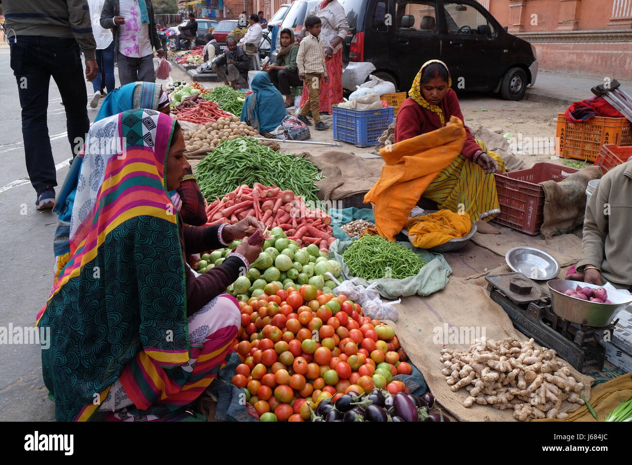 JAIPUR, Indien - Februar 16: Indische Frauen in bunten Saris kaufen Obst und Gemüse von der Seite der Straße in Jaipur, Rajasthan, Indien auf Stockfoto