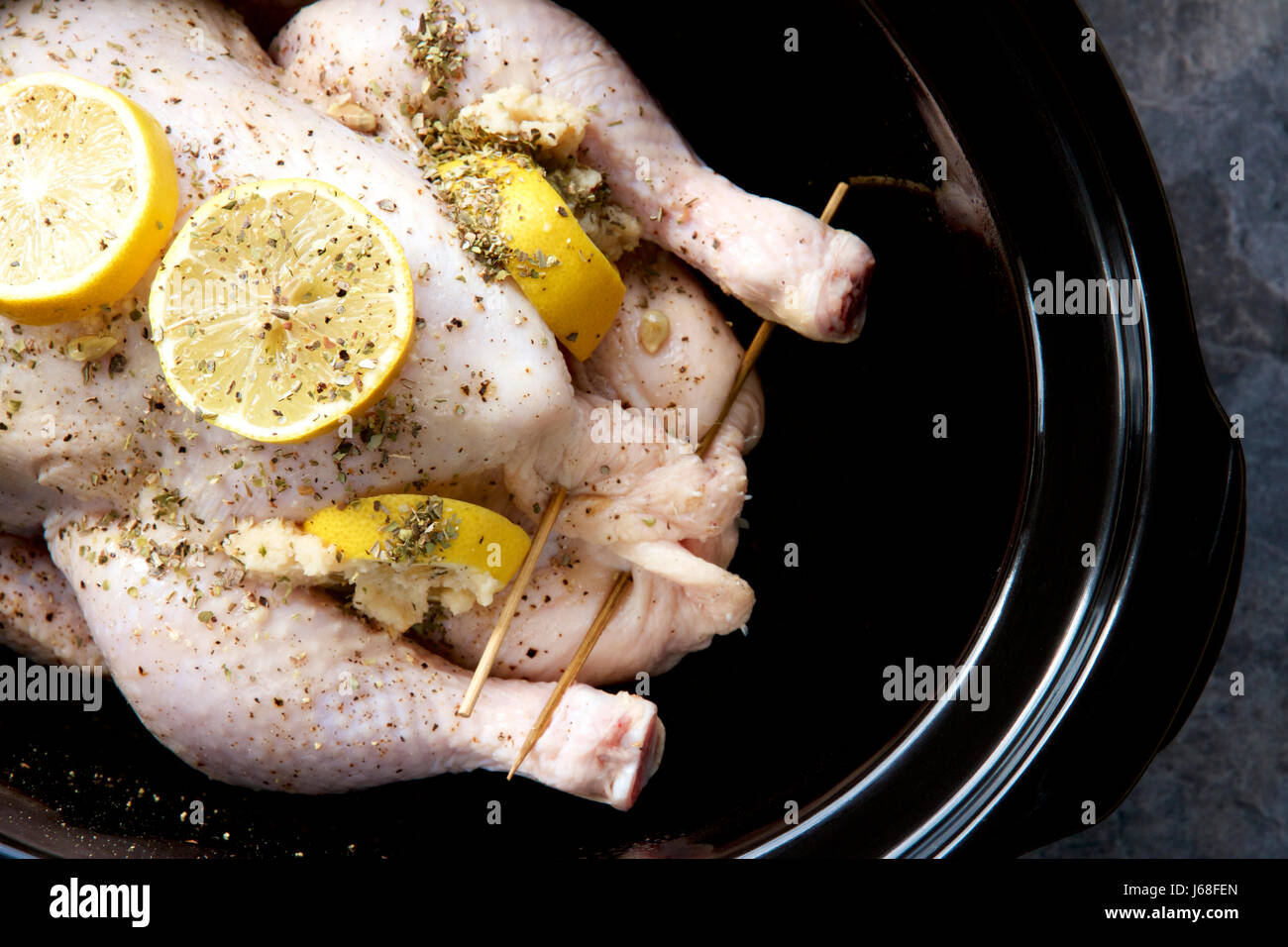 Gefüllte Hähnchen, Zitrone und Kräutern in einem langsamen Kocher. Stockfoto