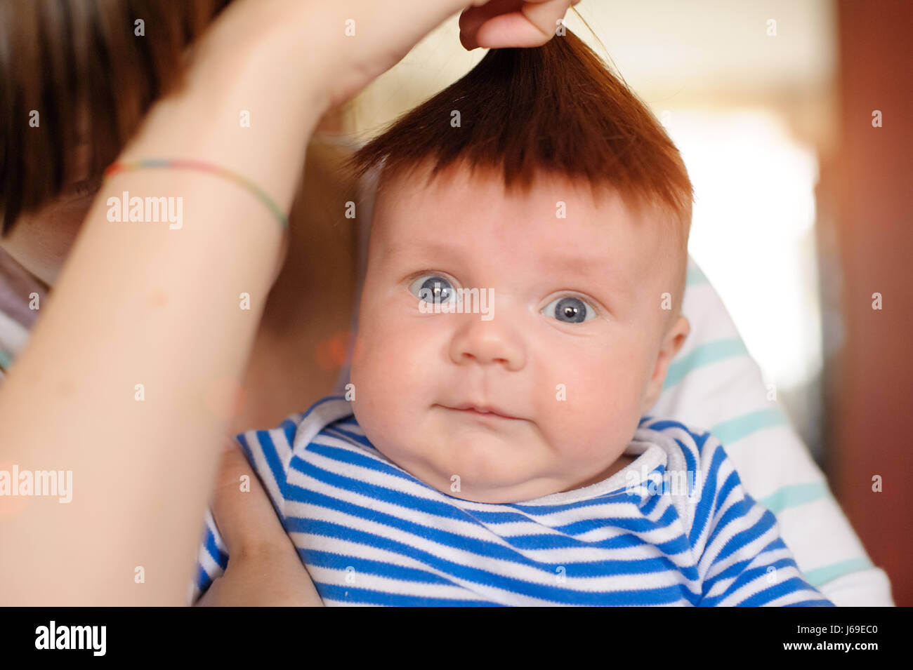 Mama Kopf des Neugeborenen Eigenhaar befestigt und Spaß haben Stockfoto