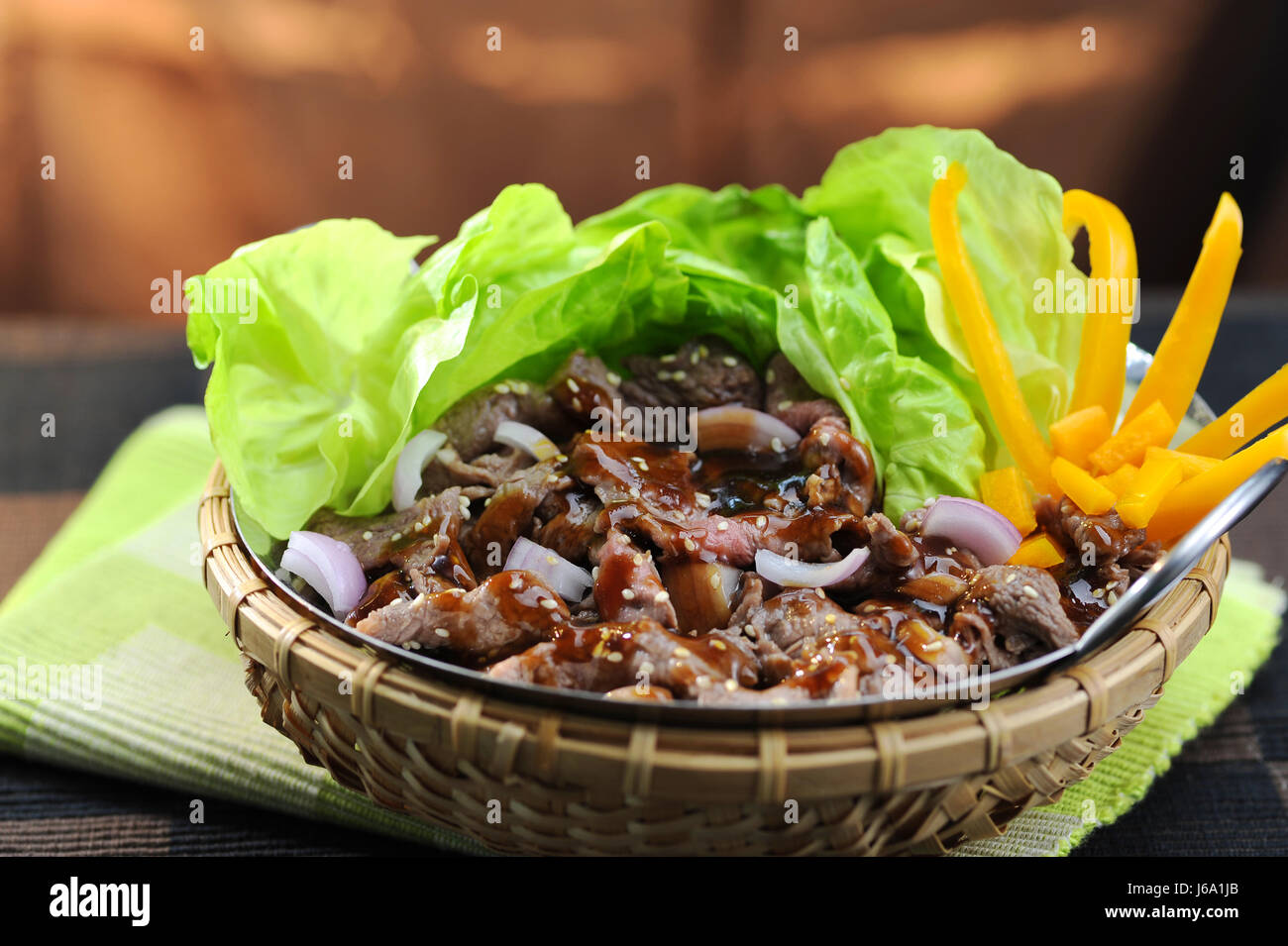 Rühren Sie gebratenes Rindfleisch mit Austern, Sauce und Salat im Bambuskorb Stockfoto