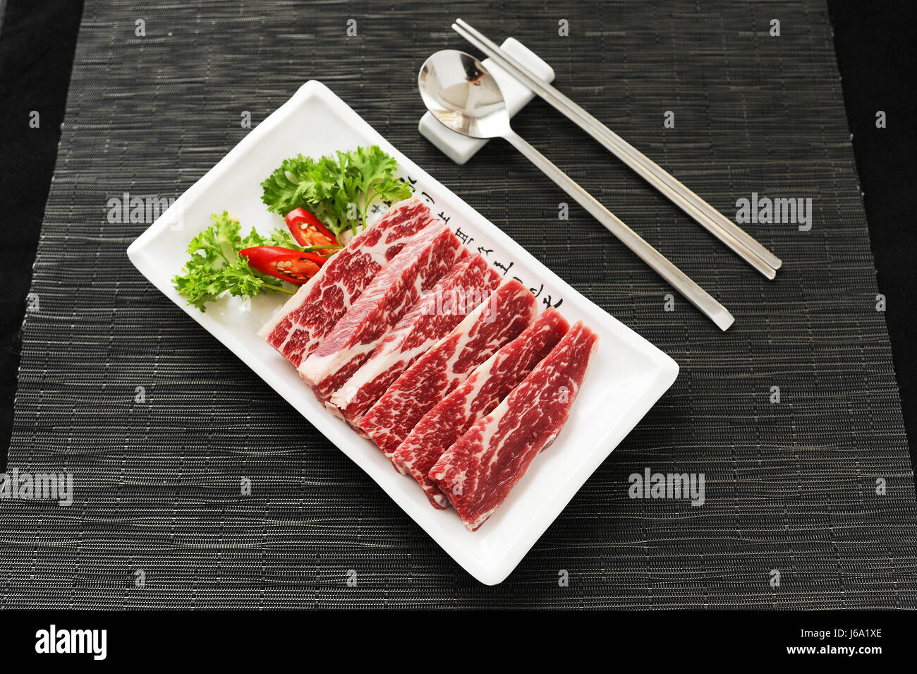Frisches Rindfleisch mit Kümmel und Chili auf weiße Platte geschnitten Stockfoto