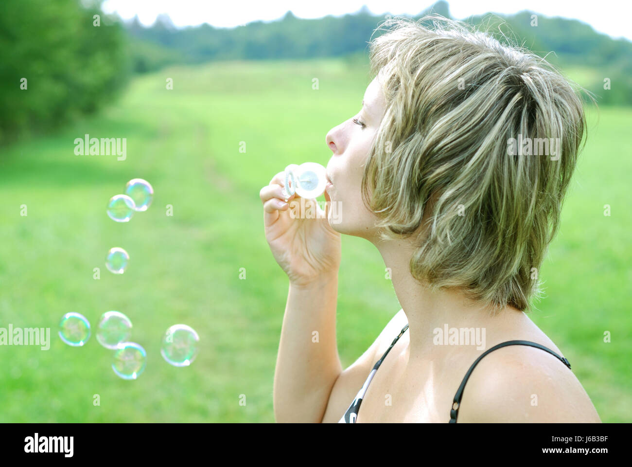 Frau Sommer sommerlich Lage Schuss Schlag Seifenblasen weibliche grüne blank Stockfoto