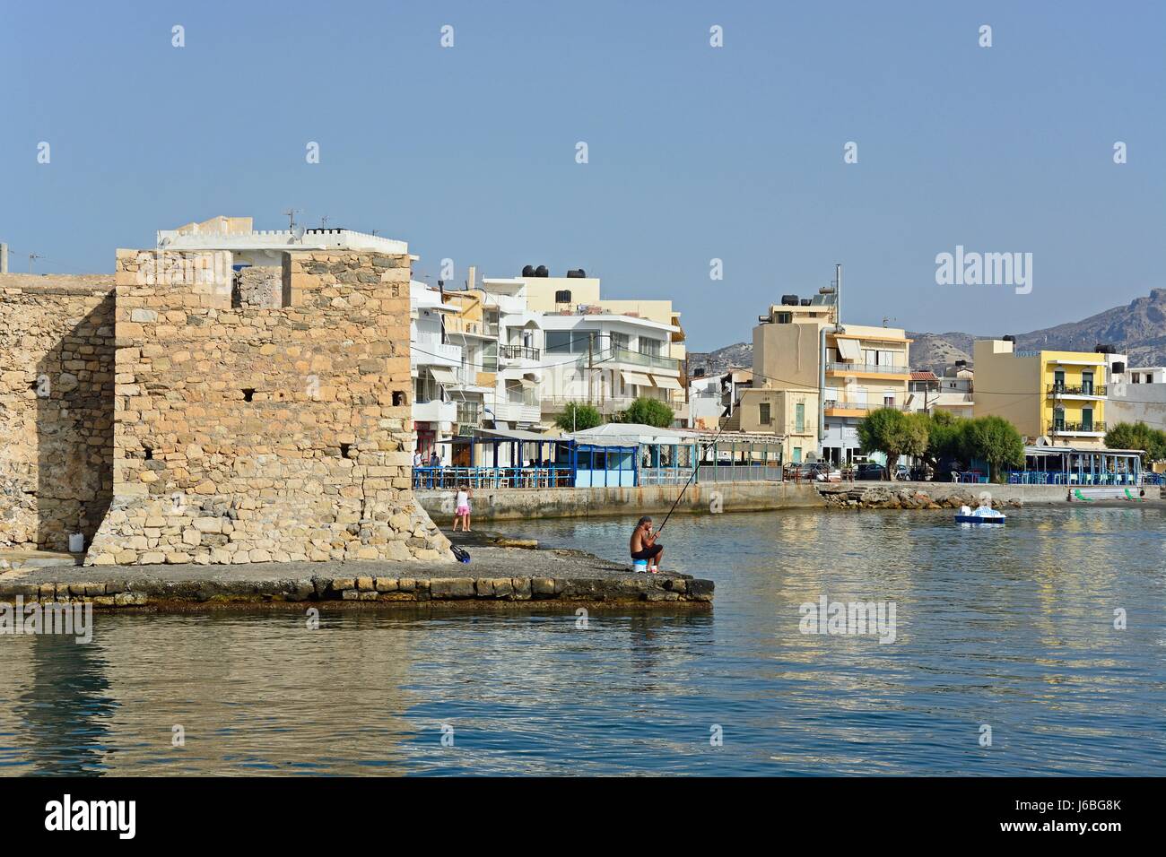 Ecke von Kales venezianische Festung an der Hafeneinfahrt mit Blick entlang der Uferpromenade, Ierapetra, Kreta, Griechenland, Europa. Stockfoto