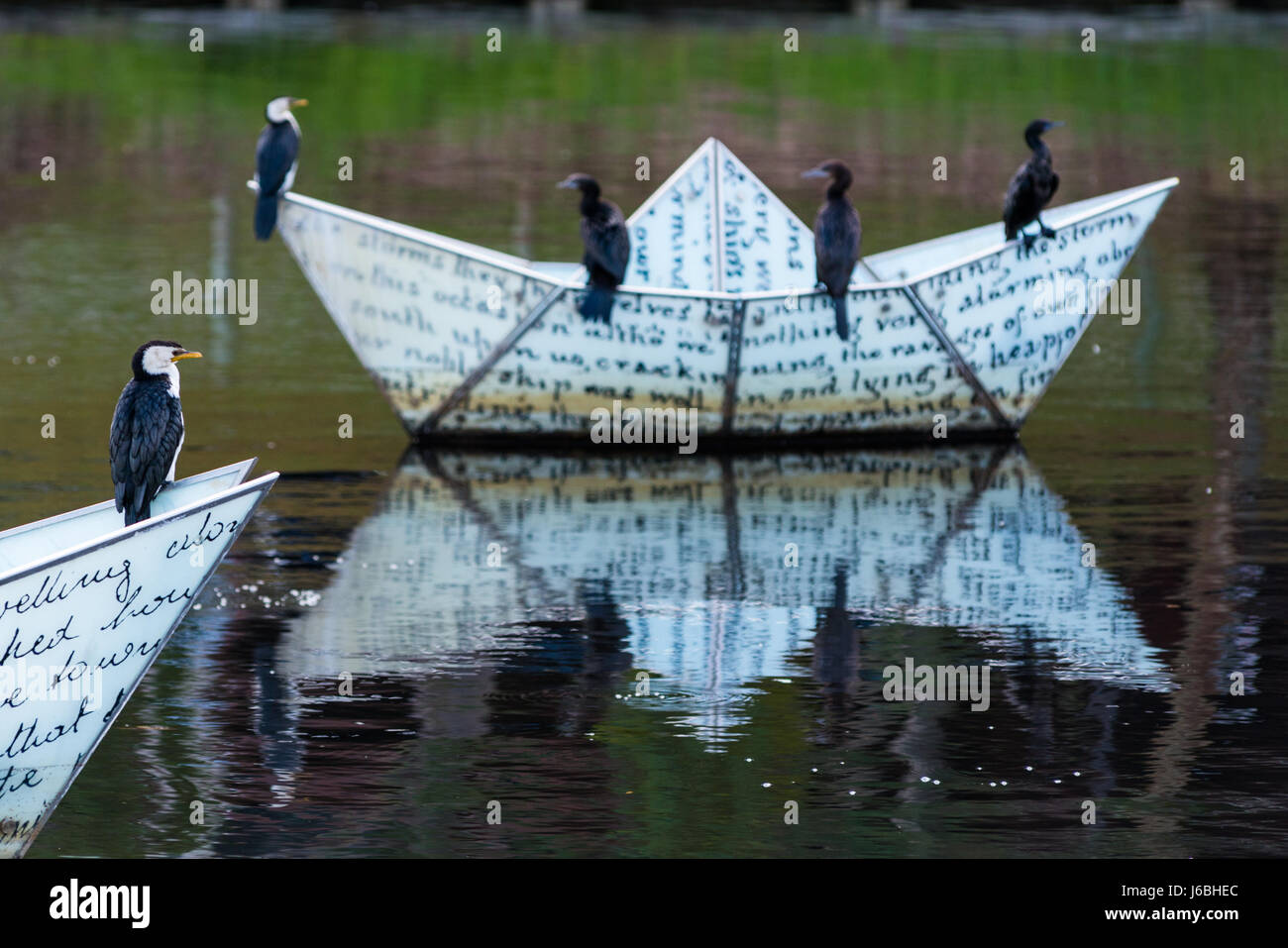 Kormorane sitzen auf dem Papier boot Skulpturen am Fluss Torrens, Adelaide, South Australia. Australien. Stockfoto