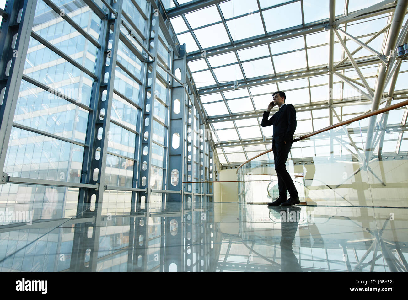 Junger Angestellter im großen modernen Businesscenter aufrufen Stockfoto