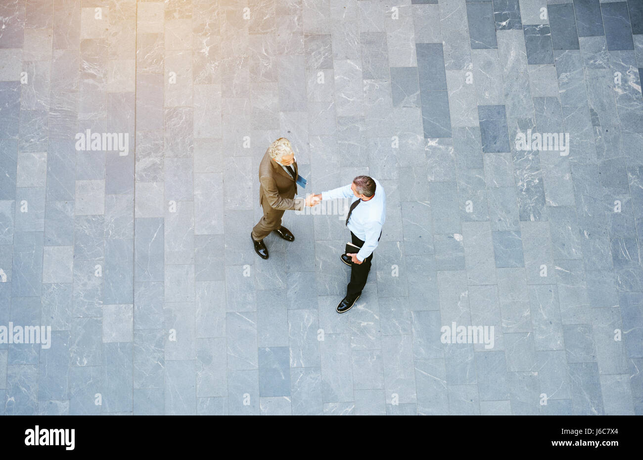 Von oben erwachsenen männlichen Büroangestellten im leeren Saal und Handshaking stehen. Stockfoto