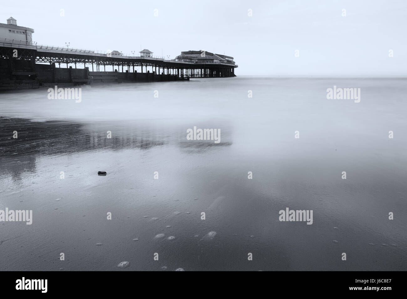 Ebbe am Cromer Pier in schwarz und weiß mit einer langen Belichtungszeit, die Wellen zu glätten und das Foto eine ätherische fühlen hinzuzufügen Stockfoto