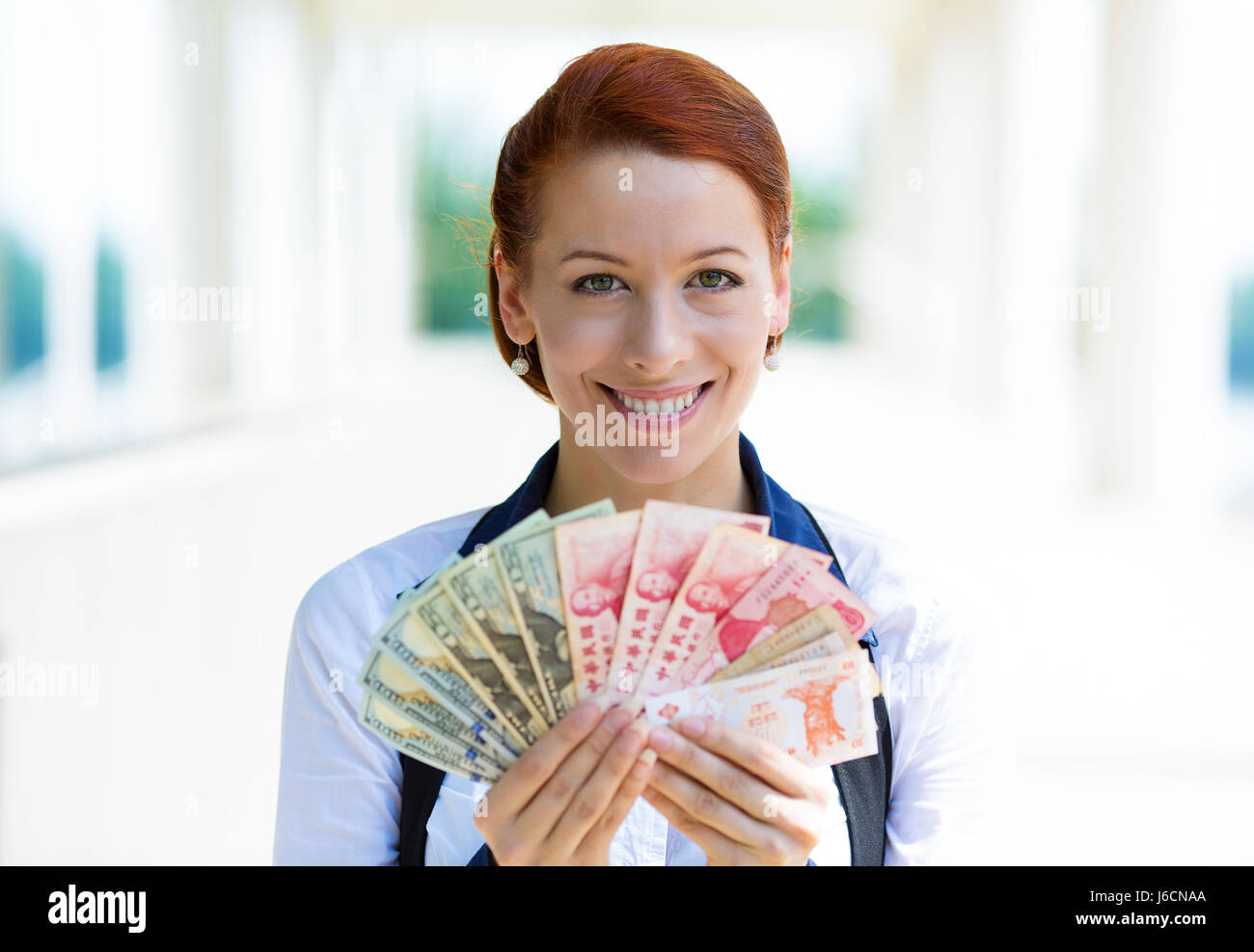 Closeup Portrait glücklich aufgeregt erfolgreiche Geschäftsfrau halten Geld Dollarnoten, Währungen aus verschiedenen Ländern in der hand, isoliert aus corporate Stockfoto