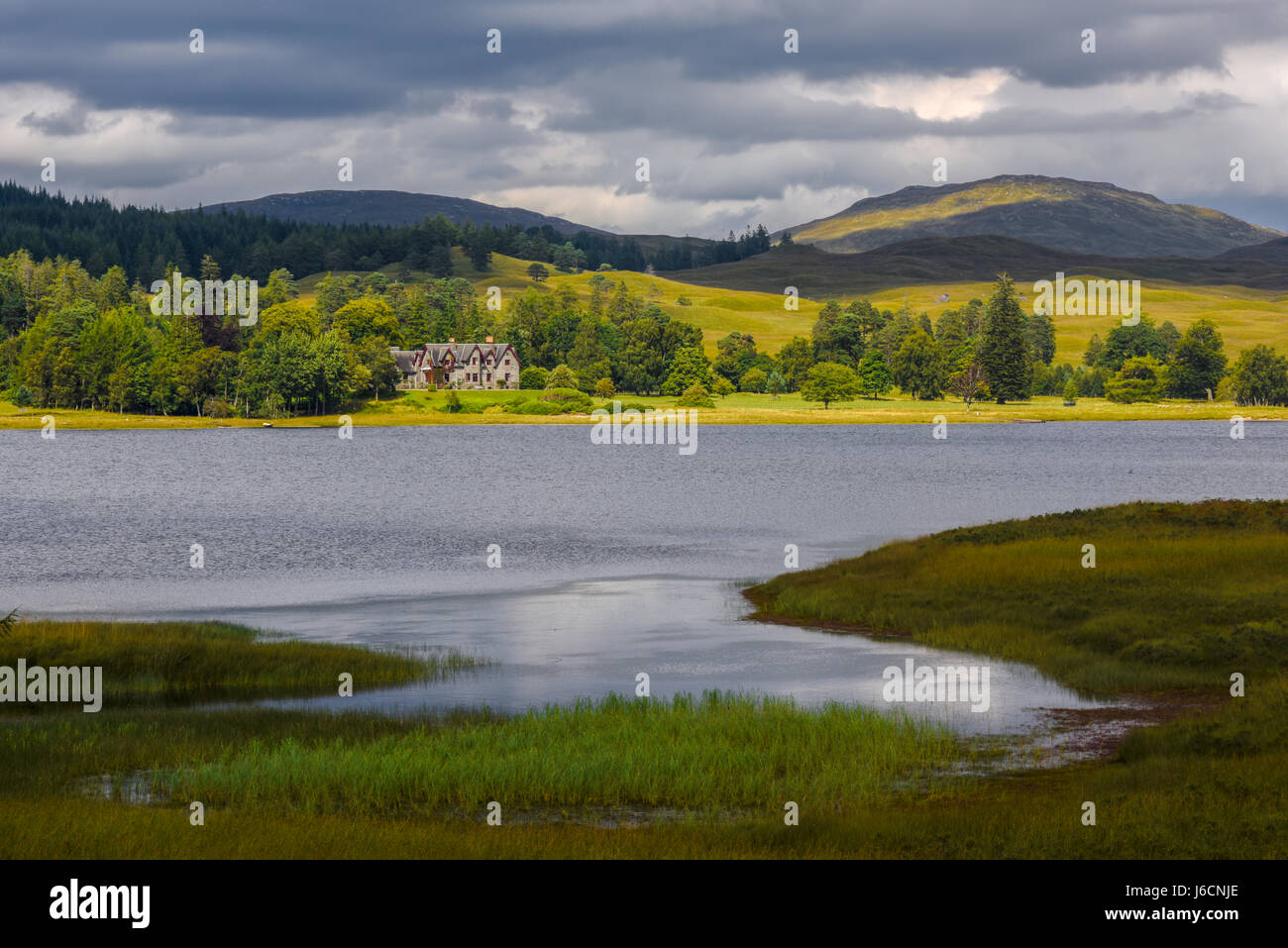 Haus auf schottischen See nach einem Gewitter. Typisch schottische Landschaft, Schottland, Vereinigtes Königreich Stockfoto