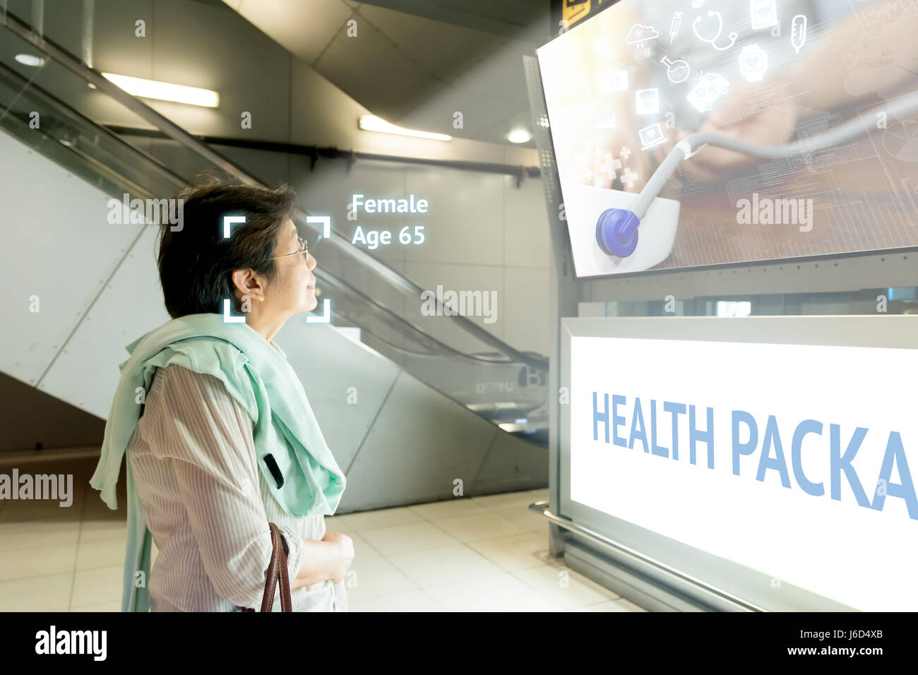Intelligentes Digital Signage Marketing und Gesicht Anerkennung Konzept. Alte Frau Watch künstliche Intelligenz digitale Anzeige über Gesundheitswesen pac Stockfoto