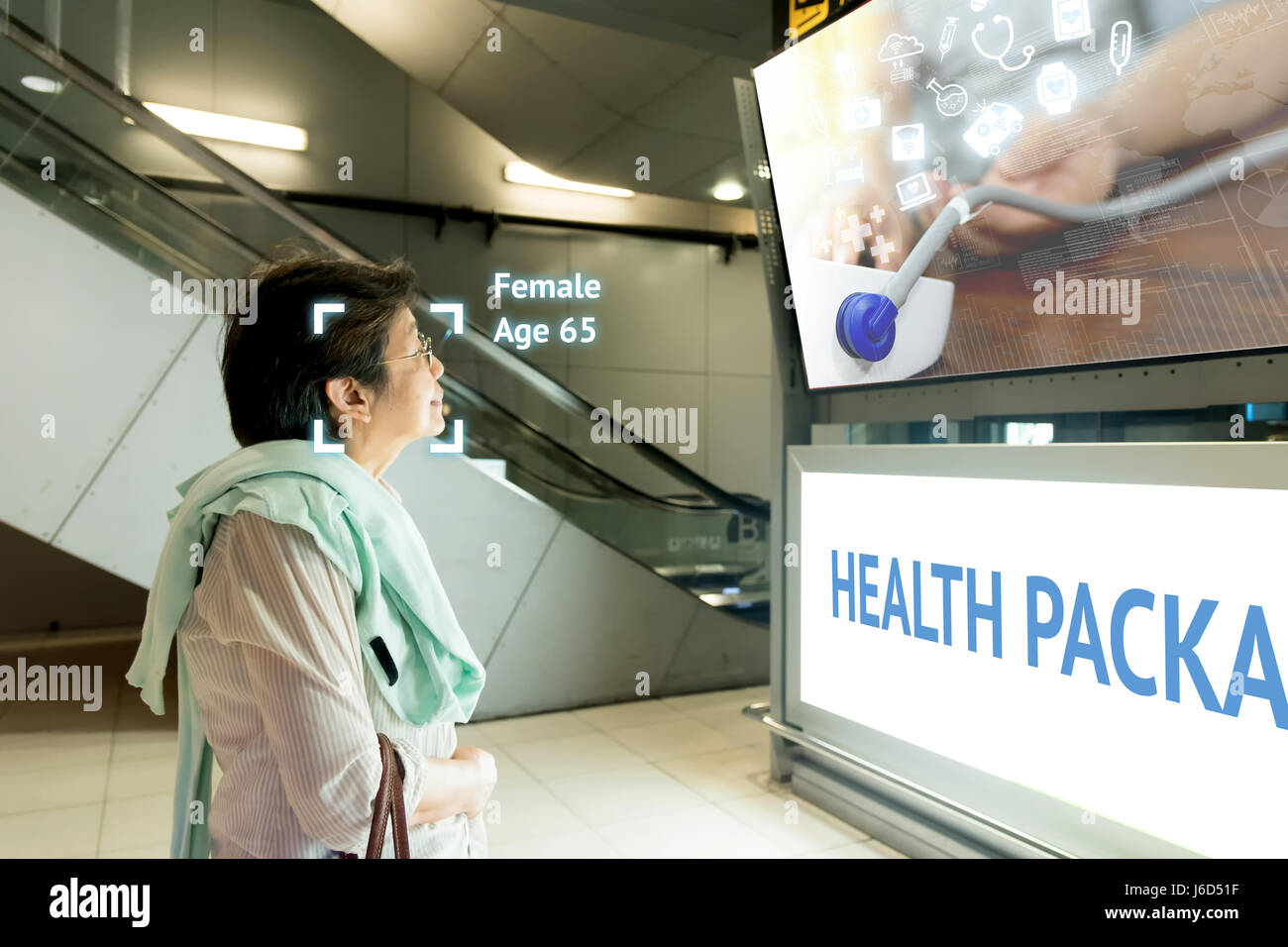 Intelligentes Digital Signage Marketing und Gesicht Anerkennung Konzept. Alte Frau Watch interaktive künstliche Intelligenz digitale Anzeige über er Stockfoto