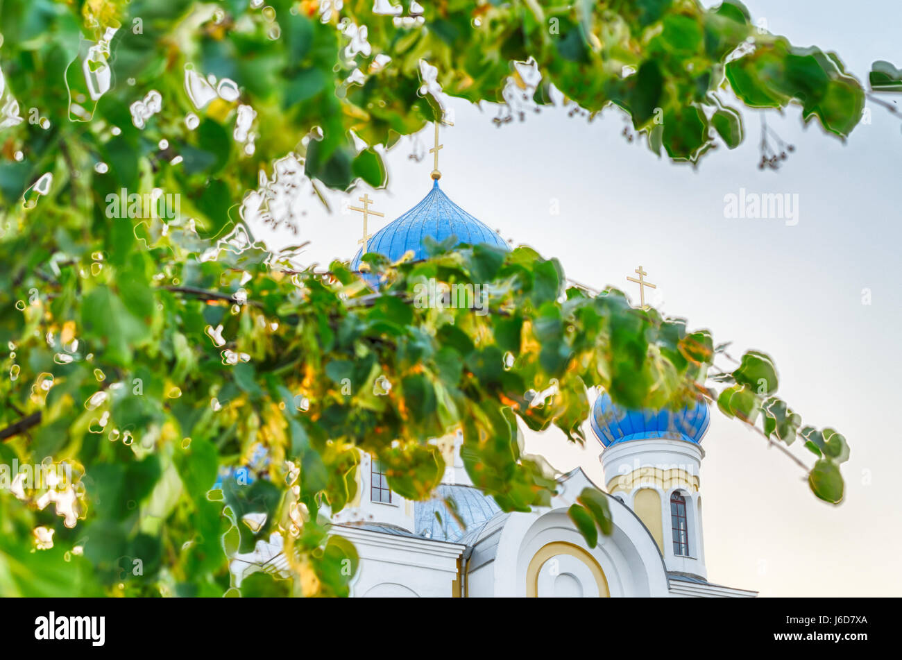 Brest, Weißrussland - 5. August 2015: Christliche Kirche mit blauen Kuppeln und goldenen Kreuzen vor der Kulisse des Sonnenuntergangs Stockfoto