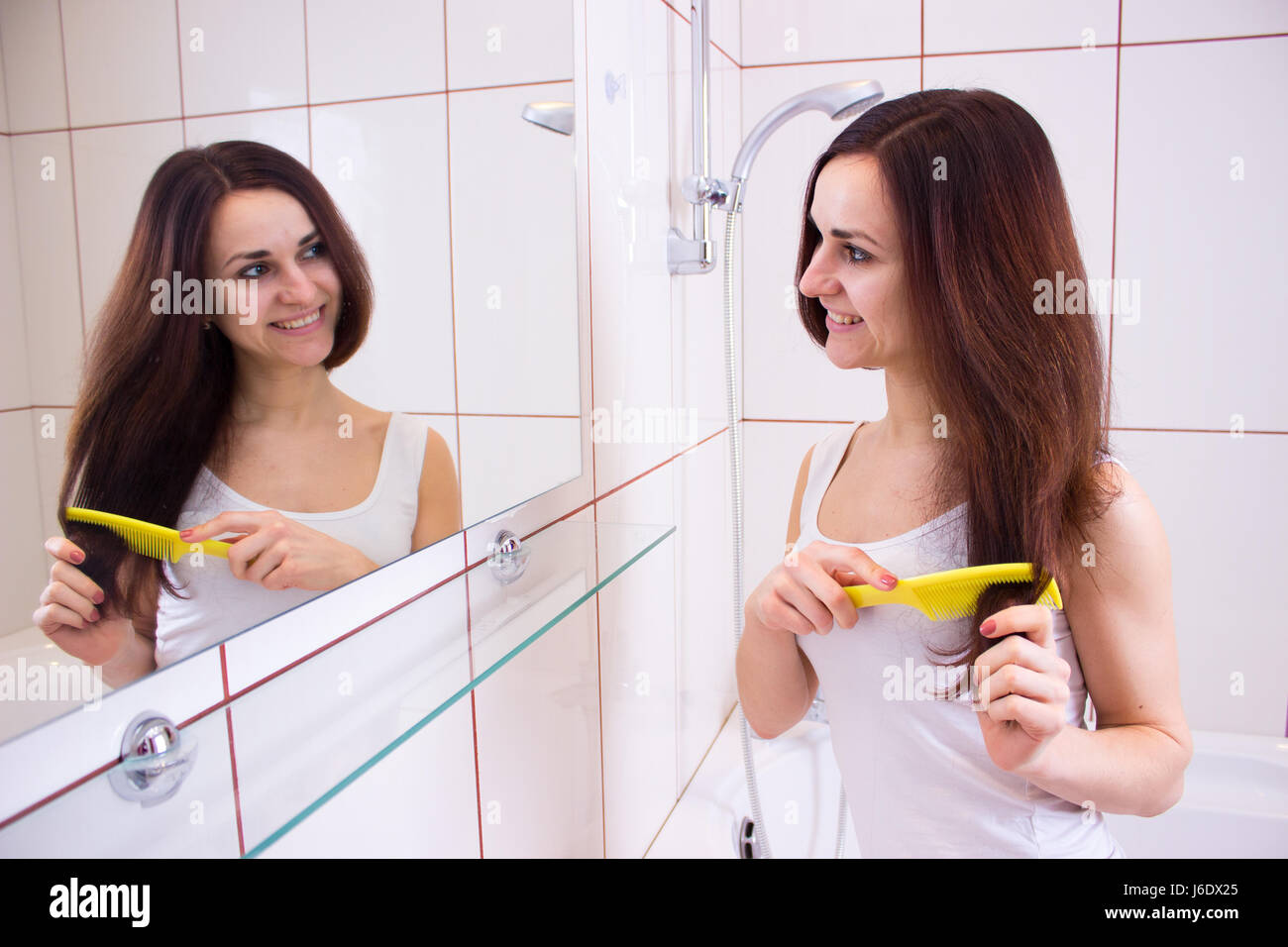 Junge Frau, Bürsten ihr Haar im Bad Stockfoto