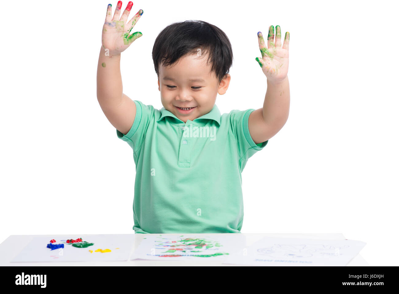 Porträt von fröhlichen asiatischen Jungen spielen mit Aquarellfarben Stockfoto