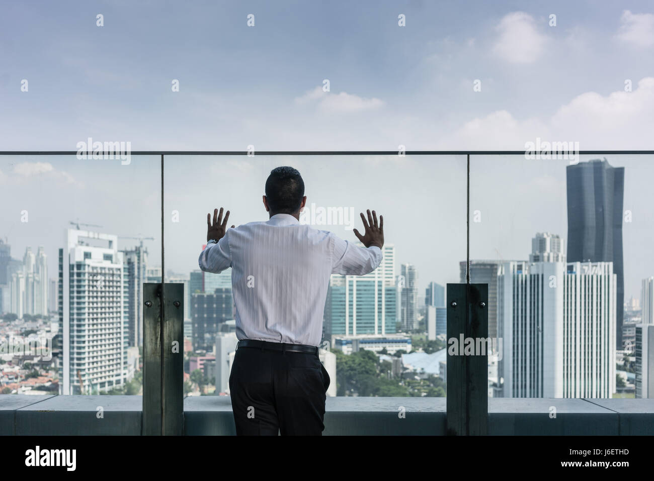 Geschäftsmann, Blick auf die Aussicht auf die Stadt vom Dach eines Gebäudes Stockfoto