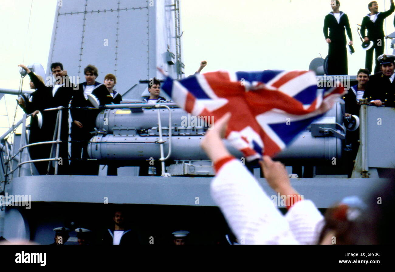 AJAXNETPHOTO. 19. JUNI. 1982. PORTSMOUTH, ENGLAND. -ÜBERLEBENDER KEHRT ZURÜCK - DIE BOMBE BESCHÄDIGT TYP 42 (1 & 2) SHEFFIELD-KLASSE ZERSTÖRER (3660 TONNEN) HMS GLASGOW KOMMT NACH HAUSE, EIN HERZLICHES WILLKOMMEN VON FLAGGE WINKEN MASSEN VON GÖNNERN.  FOTO: JONATHAN EASTLAND/AJAX. REF: 910820 Stockfoto