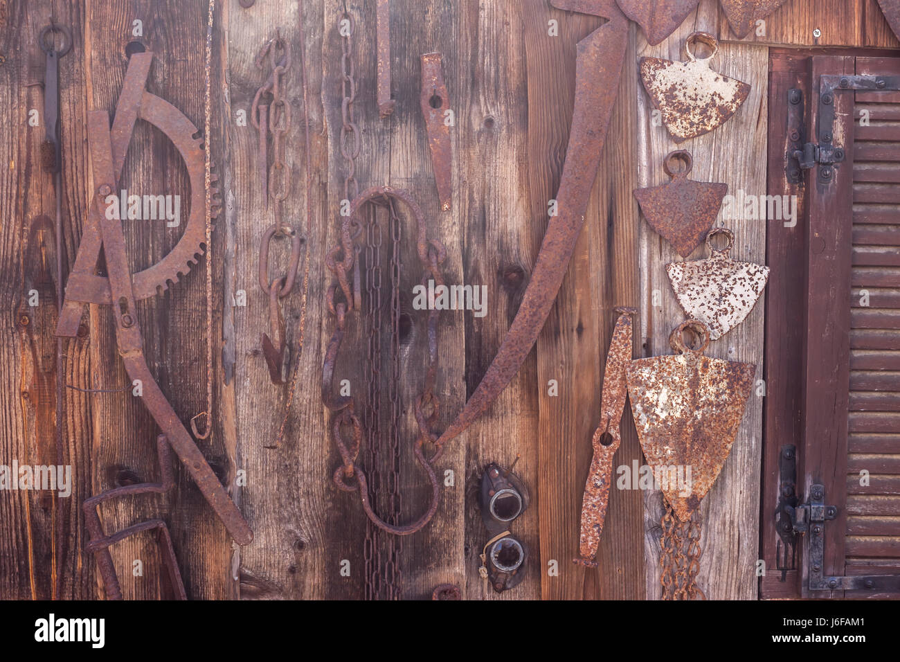 Landw. Geräte hängen braun Holzwand Stockfoto