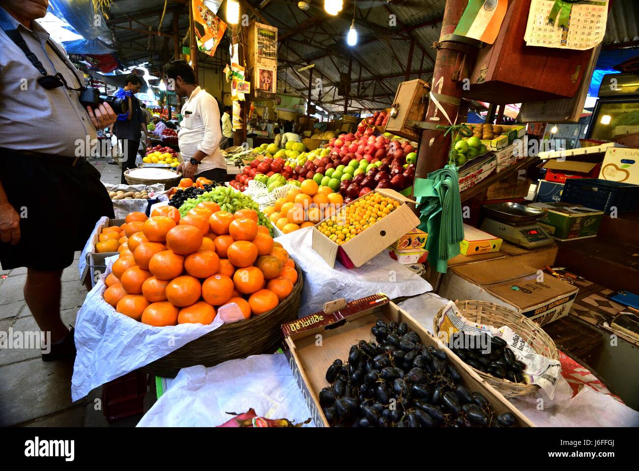 Touristen, die die Frucht auf dem Display in Crawford Market, Mumbai anzeigen Stockfoto