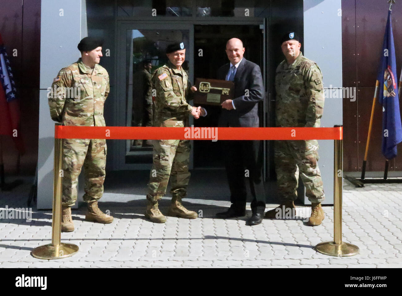 John Adams, stellvertretender Bezirk Ingenieur von US Armee-Korps der Ingenieure Europa Viertel präsentiert eine zeremonielle wichtige Plakette Oberst Jeff Worthington, Kommandeur der 2. Theater Signal Brigade, an einer Banddurchtrennungszeremonie der US Army Signal Aktivität Kaiserslautern Headquarter und Betriebsgebäude 15. Mai 2017 in Landstuhl, Deutschland offiziell eröffnet. (US Armee-Foto von William B. King) Stockfoto