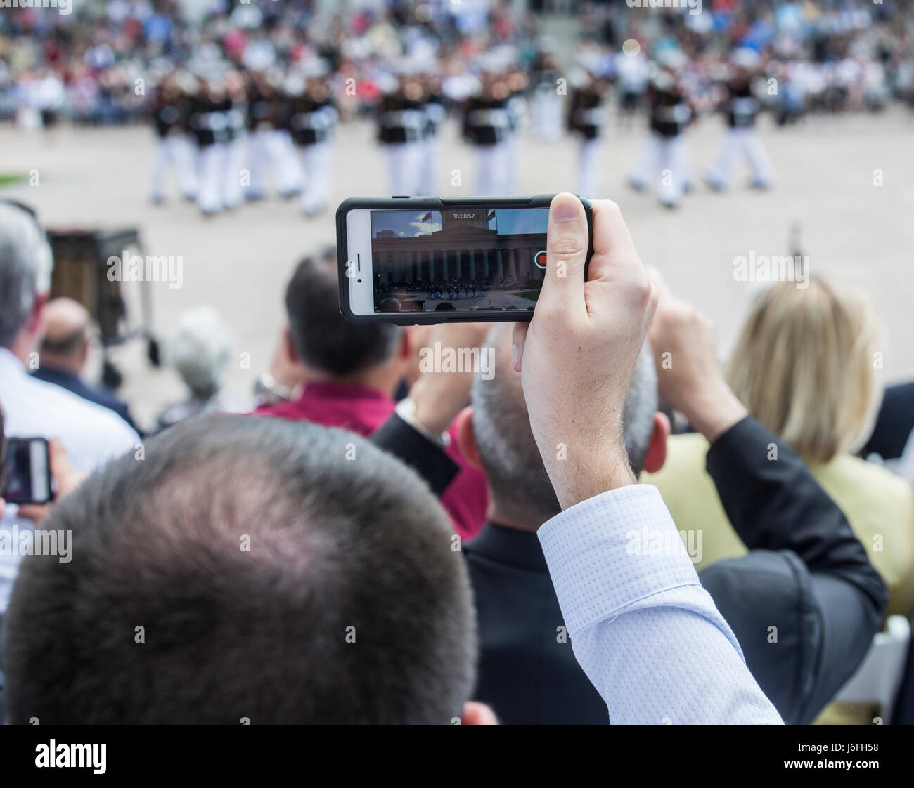 Ein Gast zeichnet das US Marine Corps Silent Drill Platoon während einer Schlacht Farbe Zeremonie am Ohio Statehouse, Columbus, Ohio, 16. Mai 2017. Das Marine Corps Schlacht Farbe ablösen wurde eingeladen und von den Lautsprecher des Ohio House Of Representatives, Clifford A. Rosenberger, tour des Statehouse und für Mitglieder des House Of Representatives und die Stadt Columbus durchführen. Im Dezember gemäß der Kaserne Marines unterstützen das public Viewing der ehemaligen Marine, Senator und Astronaut John Glenn, bei dem Statehouse. Teilnahme an der Schlacht Farbe Zeremonie war Glenns Witwe, Stockfoto