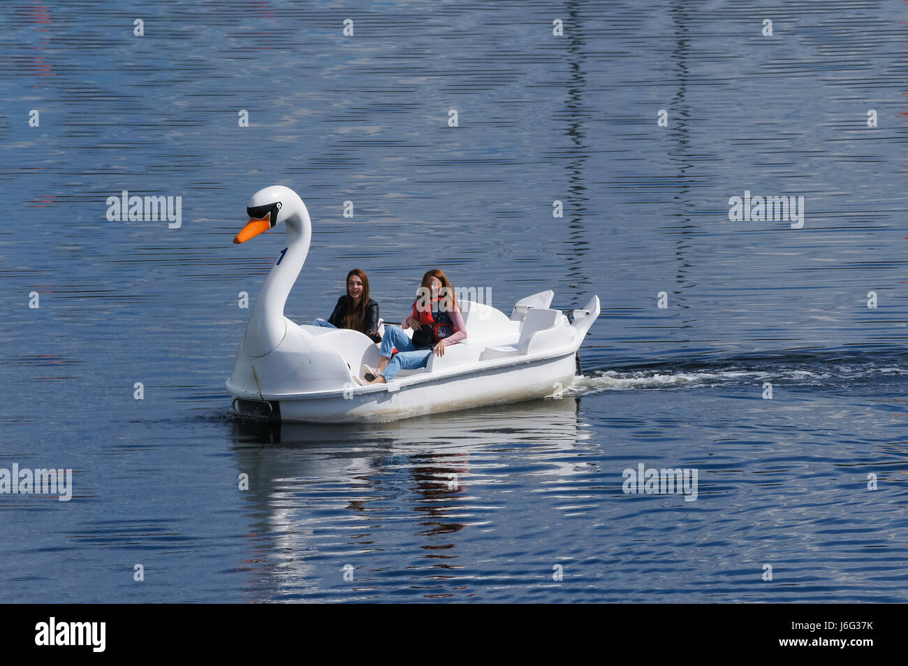 Die Menschen genießen heißen Tag in Swan Tretboote am Fluss Lea im Queen Elizabeth Olympic Park, London England United Kingdom UK Stockfoto