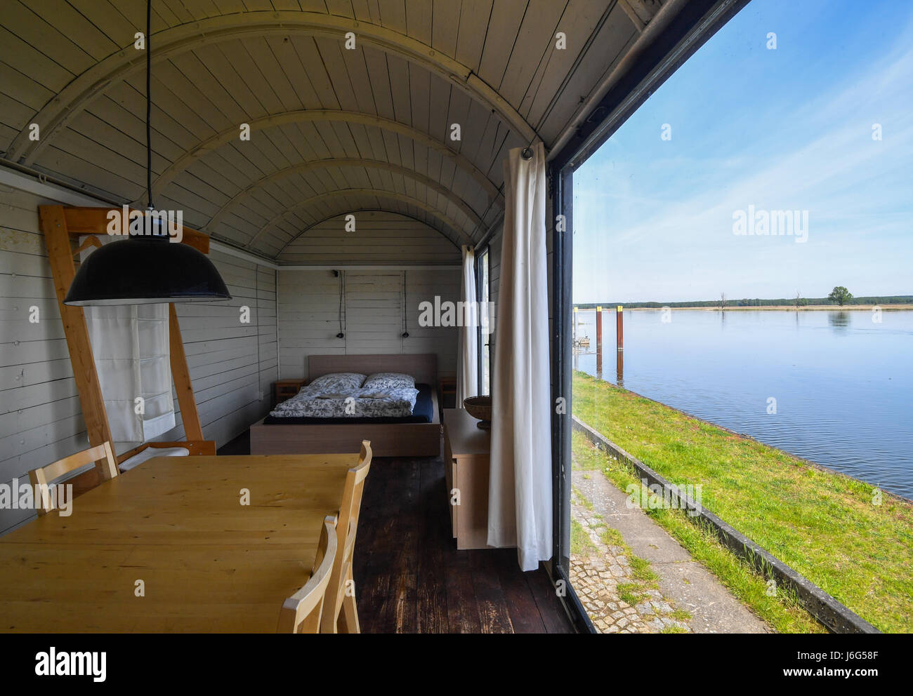 Brutto-Neuendorf, Deutschland. 17. Mai 2017. Eine stillgelegte Bahn-Kutsche, die in ein Ferienhaus umgewandelt wurde bietet einen tollen Blick auf die deutsch-polnischen Grenzfluss Oder in den Hafen der Gross Neuendorf, Deutschland, 17. Mai 2017. Die historischen Eisenbahnwagen sind auf den Spuren der ehemaligen Oderbruch Bahn im Hafen von Brutto Neuendorf geparkt. Foto: Patrick Pleul/Dpa-Zentralbild/ZB/Dpa/Alamy Live News Stockfoto