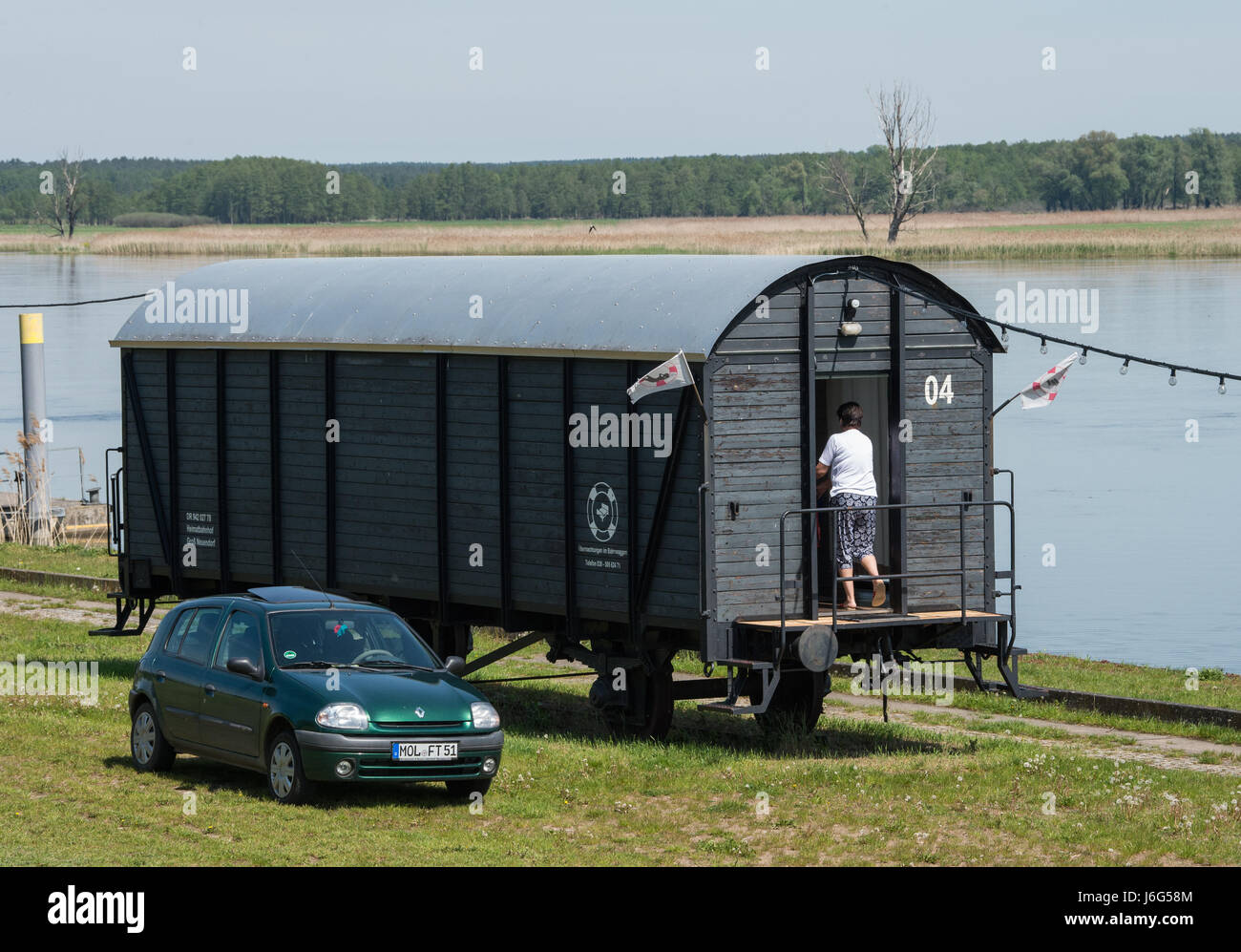 Brutto-Neuendorf, Deutschland. 17. Mai 2017. Eine stillgelegte Bahn-Kutsche, die in ein Ferienhaus umgewandelt wurde bietet einen tollen Blick auf die deutsch-polnischen Grenzfluss Oder in den Hafen der Gross Neuendorf, Deutschland, 17. Mai 2017. Die historischen Eisenbahnwagen sind auf den Spuren der ehemaligen Oderbruch Bahn im Hafen von Brutto Neuendorf geparkt. Foto: Patrick Pleul/Dpa-Zentralbild/ZB/Dpa/Alamy Live News Stockfoto