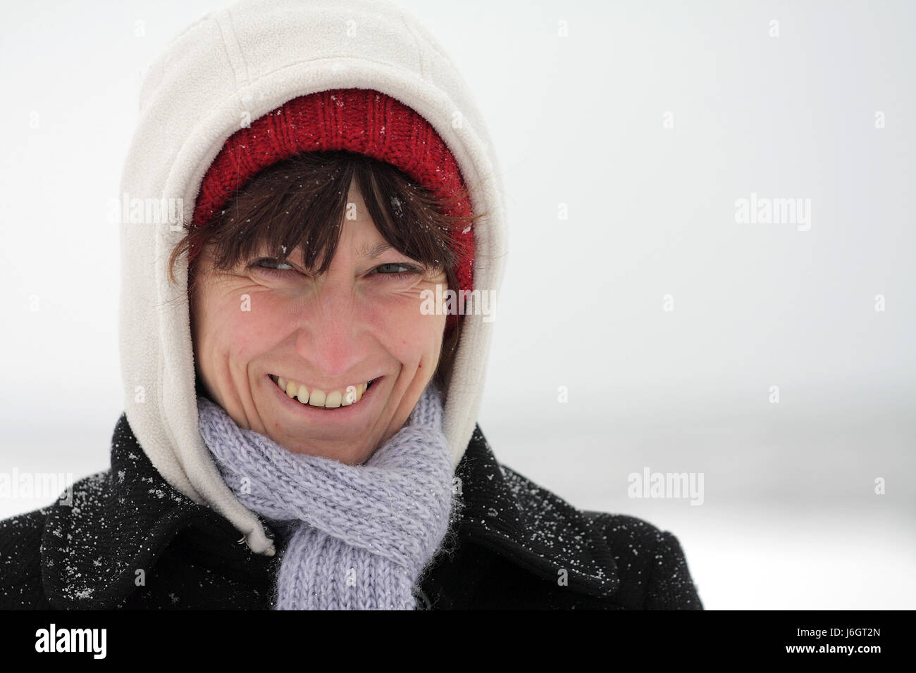 Frau Winter Porträt Mütze Schal Umhänge Flocke Schnee Mantel Mantel Lachen lacht Stockfoto