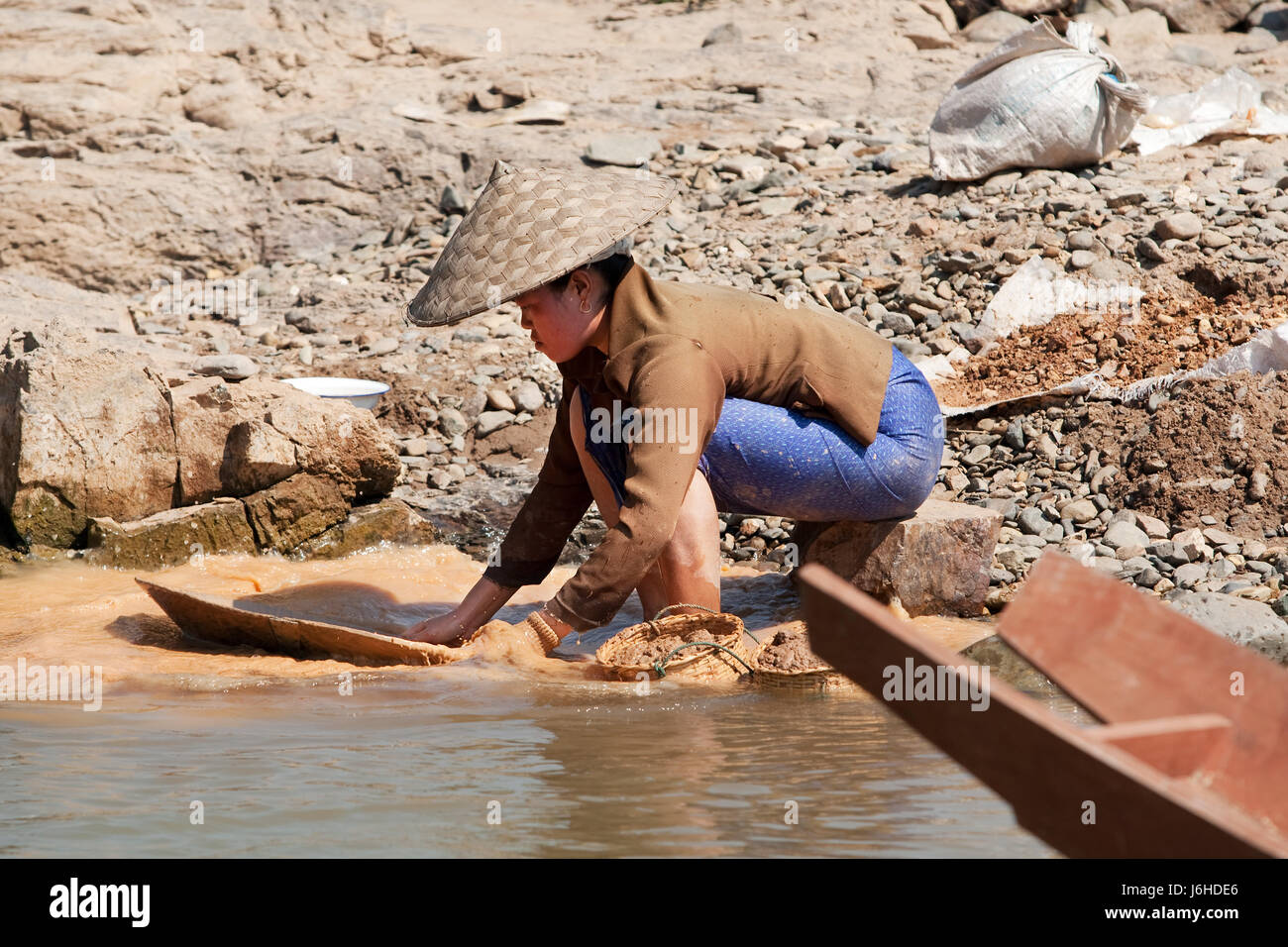 Asia Gold Rush Goldwäscher gold Wasser Frau Stein Asien Porträt Flussfelsen waschen Stockfoto