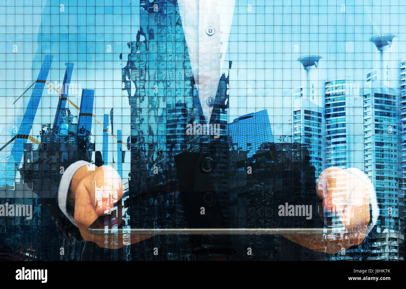 FinTech Konzept Bild. -Man-Anzug hält Tablet abstrakte Gebäude für den Hintergrund. Stockfoto