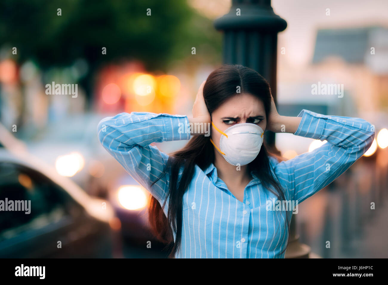 Mädchen mit Maske für ihre Ohren wegen der Lärmbelästigung Stockfoto